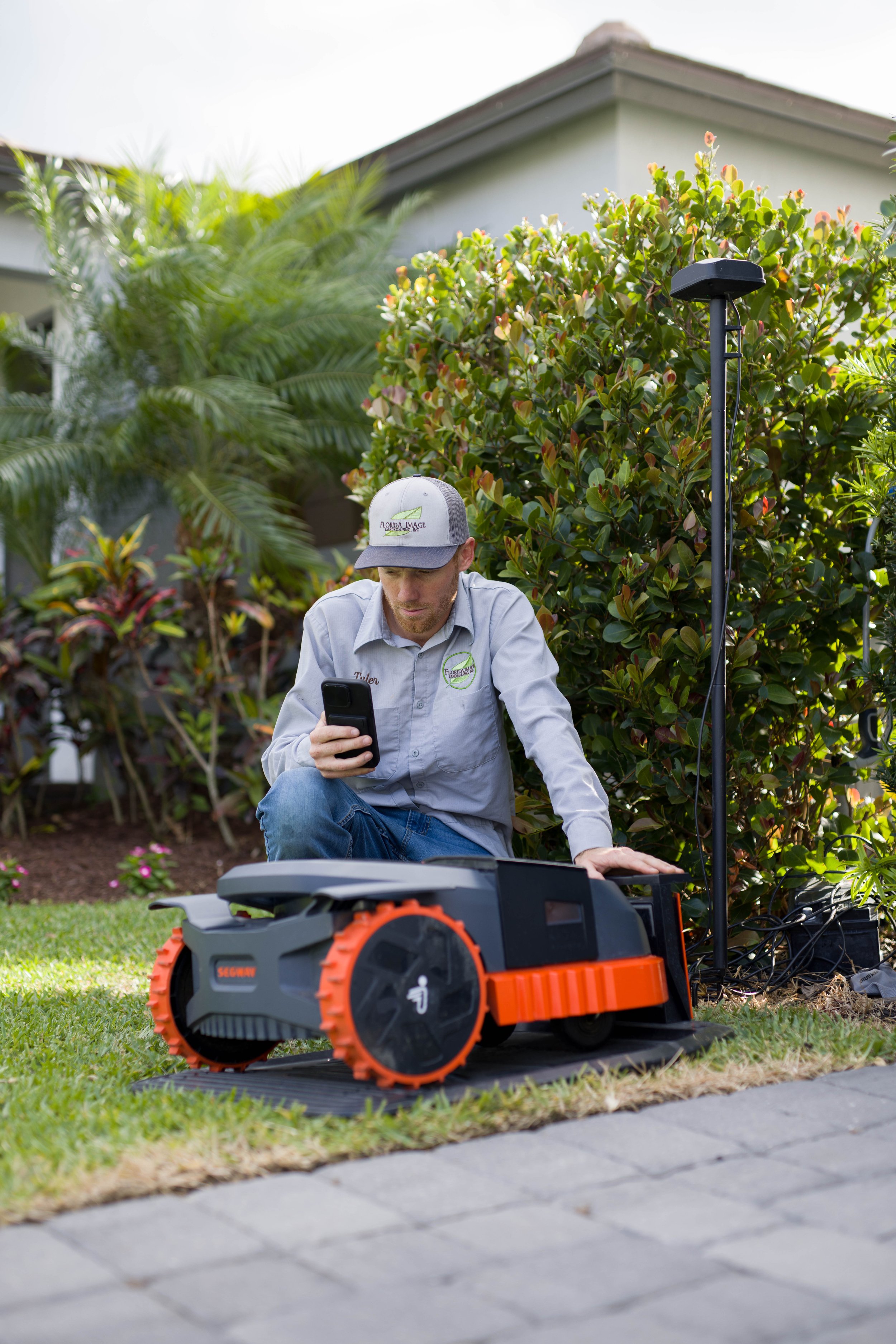 Mowtek team member with a robotic mower on a lawn