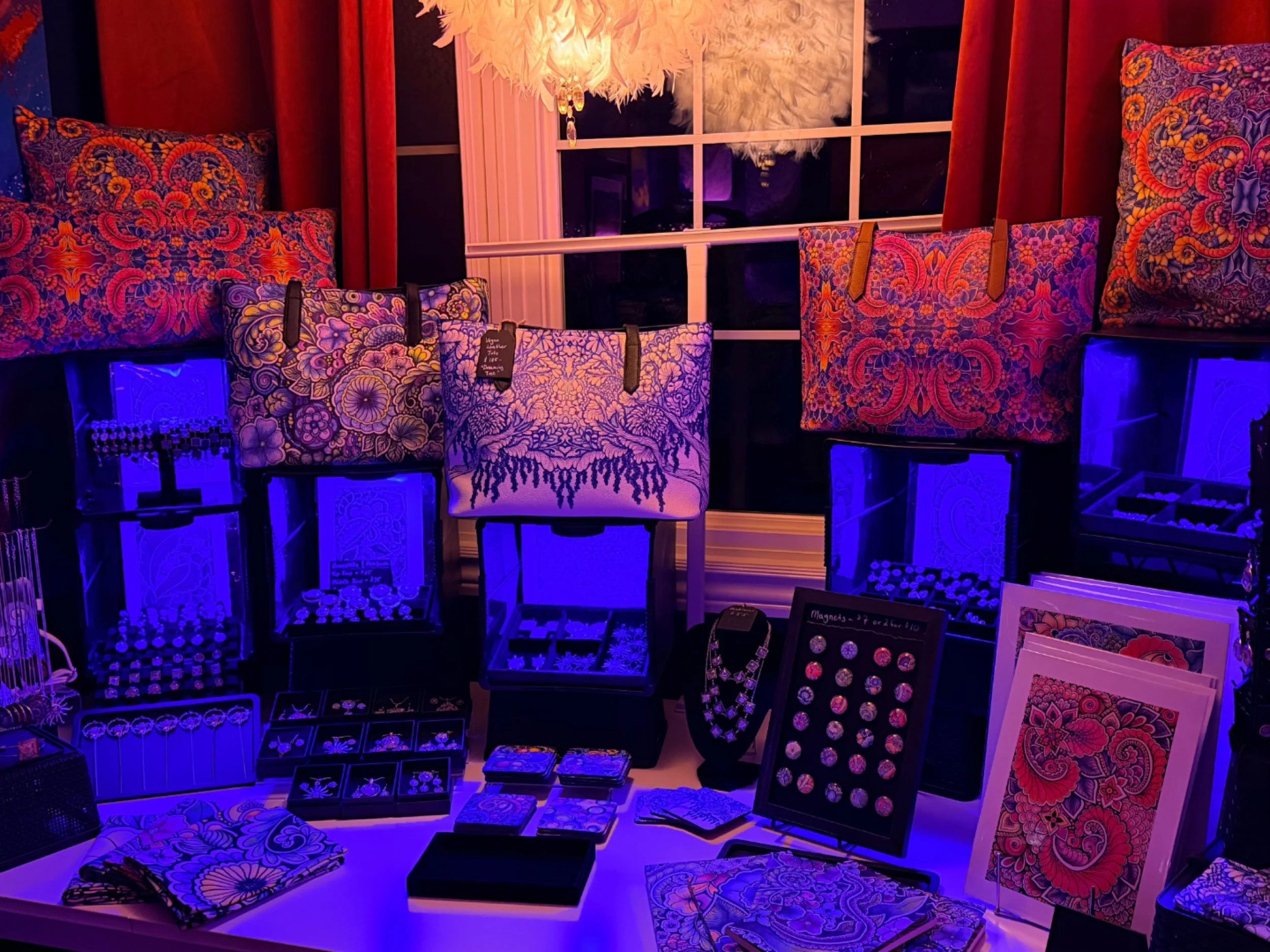 I&rsquo;ve been continually tweaking my market booth set up, and decided to add some extra lighting. I got these cute RGB LED rechargeable puck lights, and while this lighting scheme does nothing for the art, I thought this photo was art in itself! H