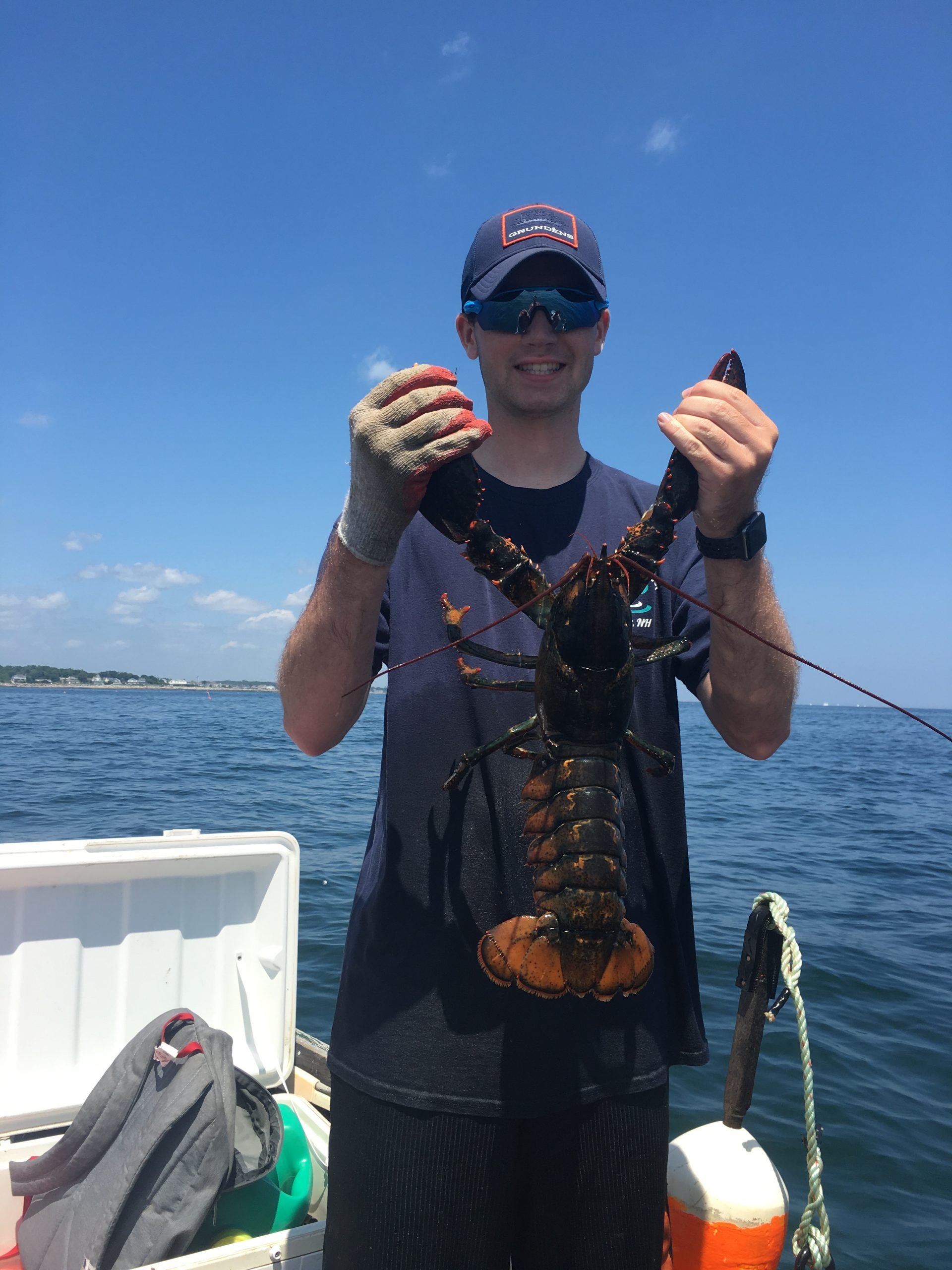 young man holding large lobster on fishing charter