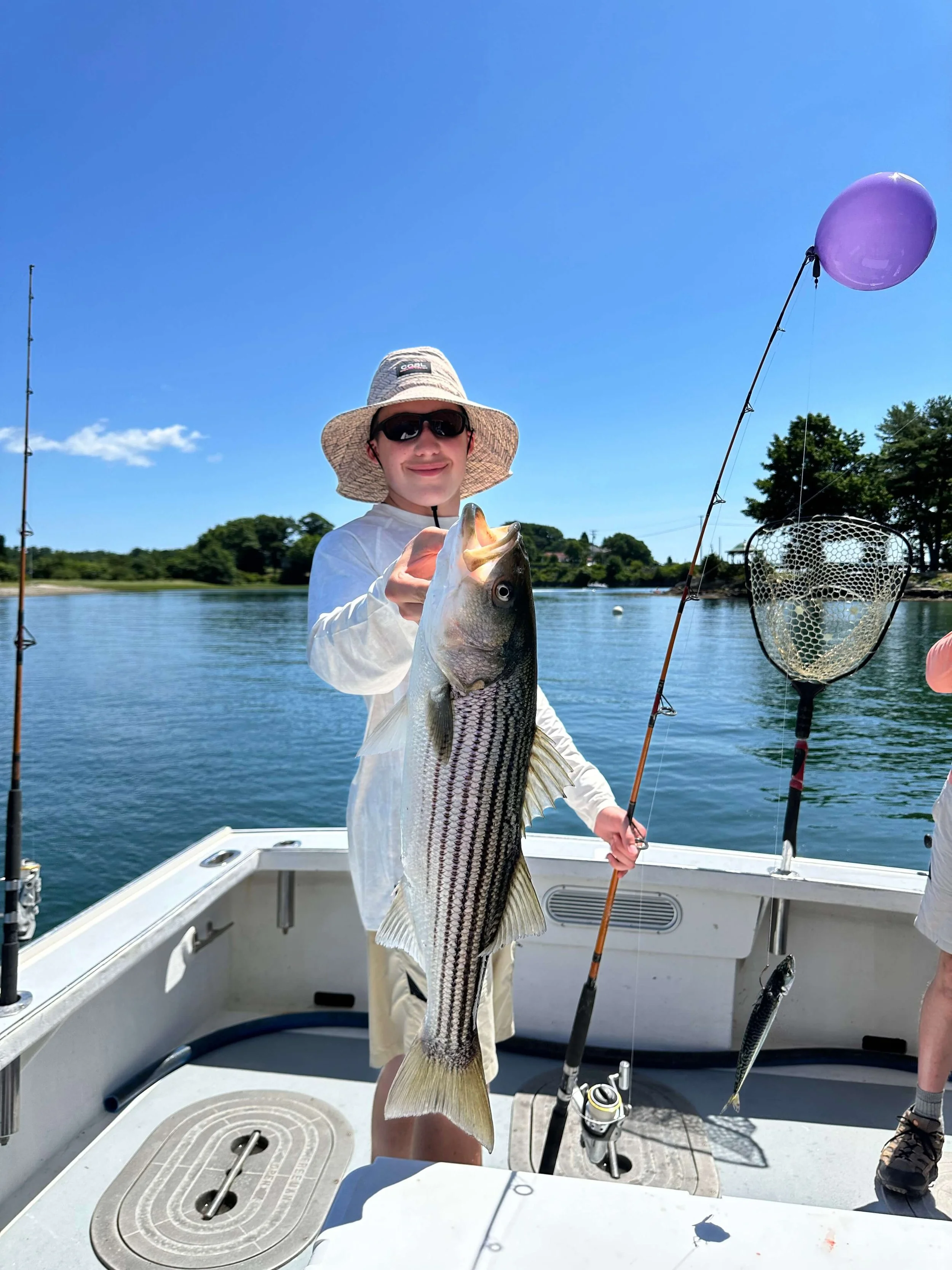 man holding a large fish on a bottom fishing boat during half day excursion in nh