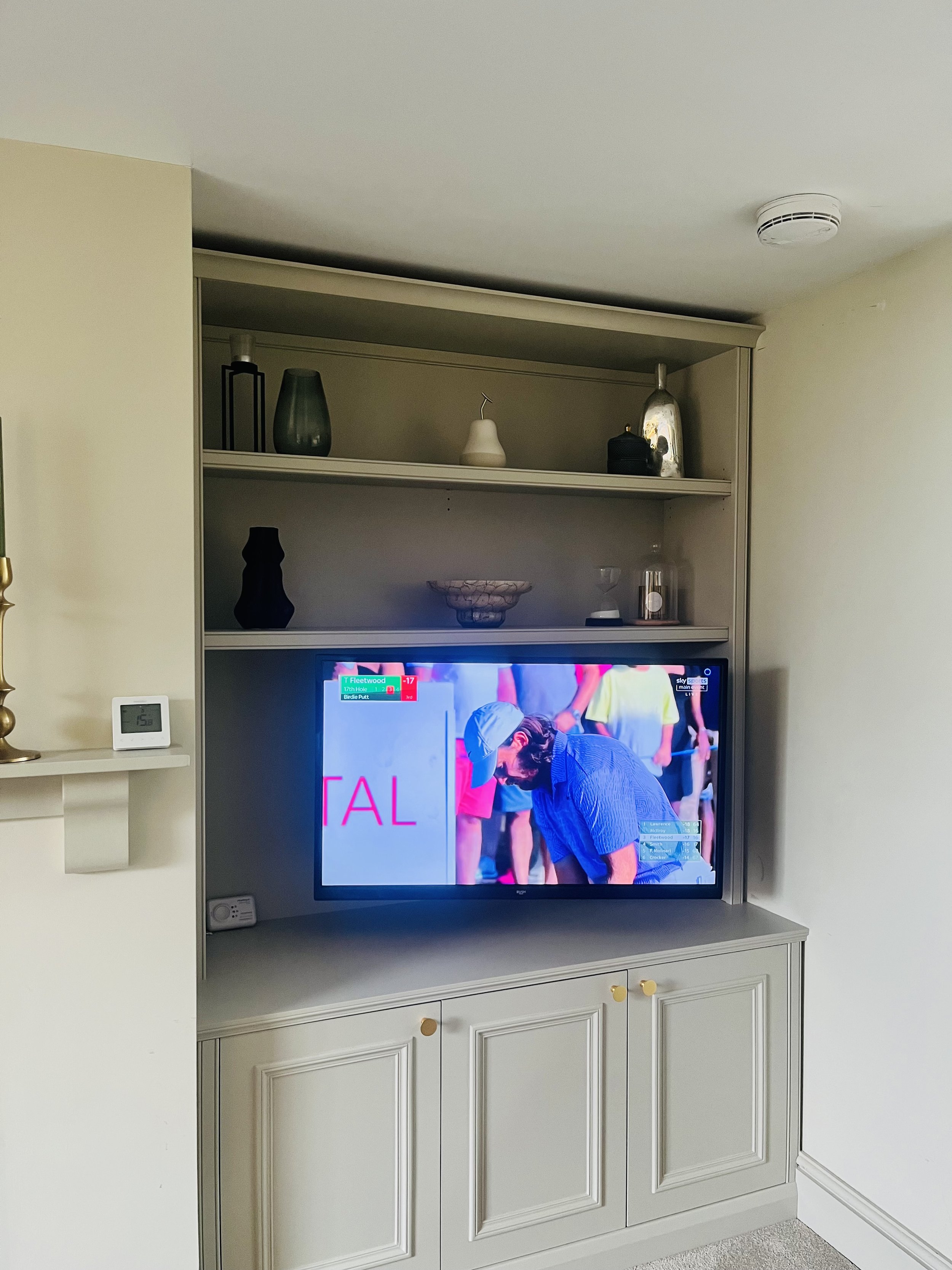 Custom built and fitted TV cabinet with moulding detail and adjustable shelves and brushed brass cabinet knobs, cable management and TV bracket by Konstruct Design