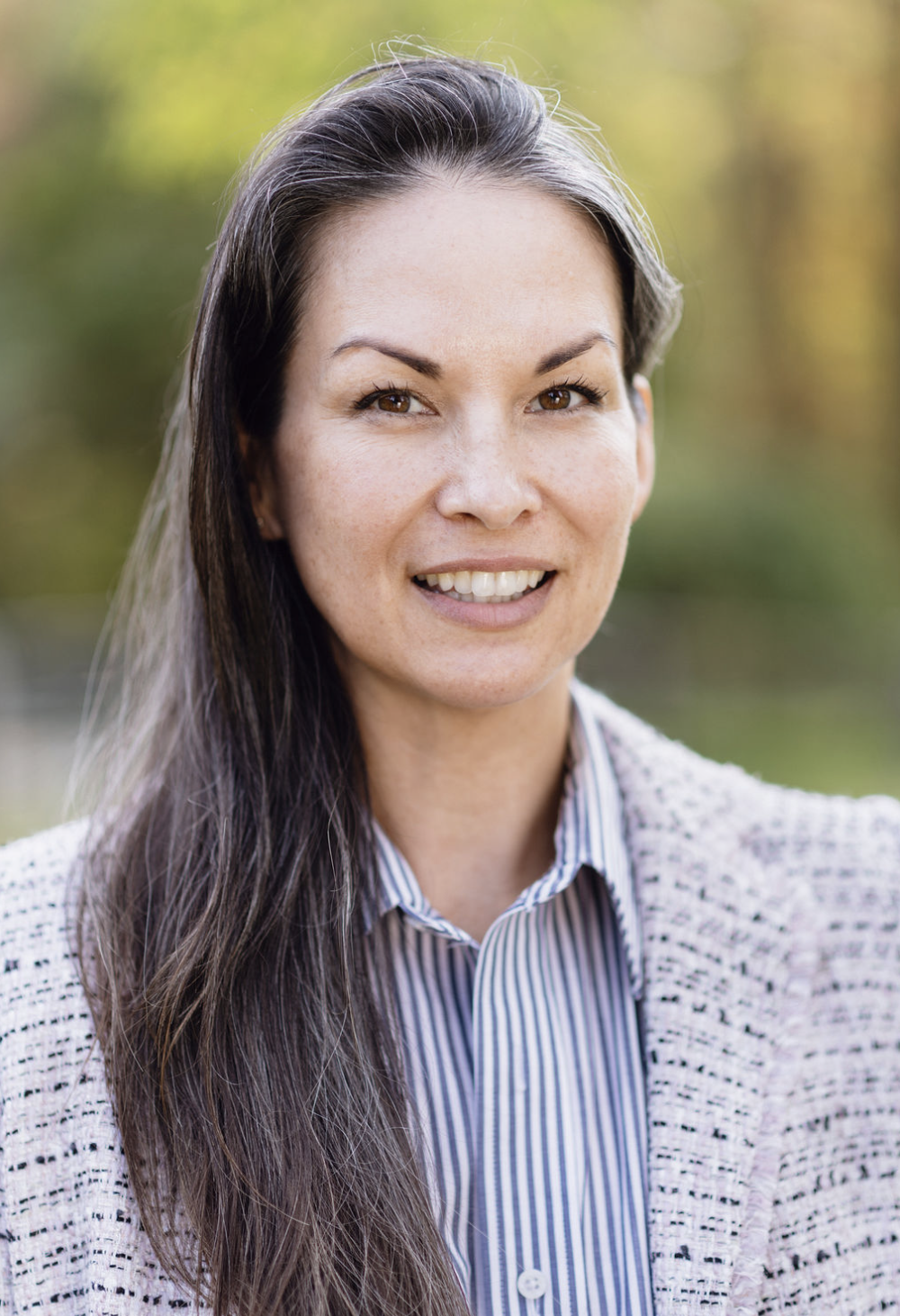 Founder Charmaine Strange in a tweed jacket with her hair down in the sunlight outside a Hudson Valley home she manages