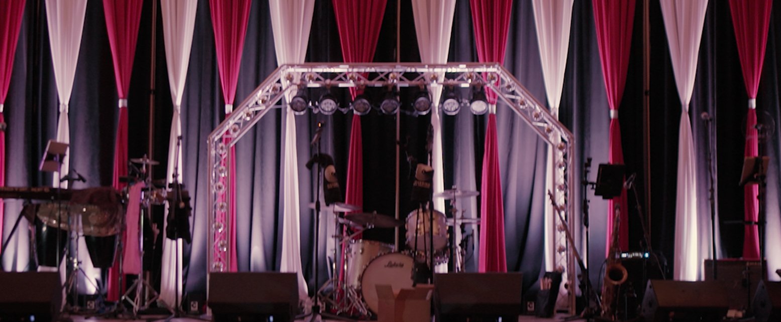 Stage with musical instruments and pink, white, and black curtains
