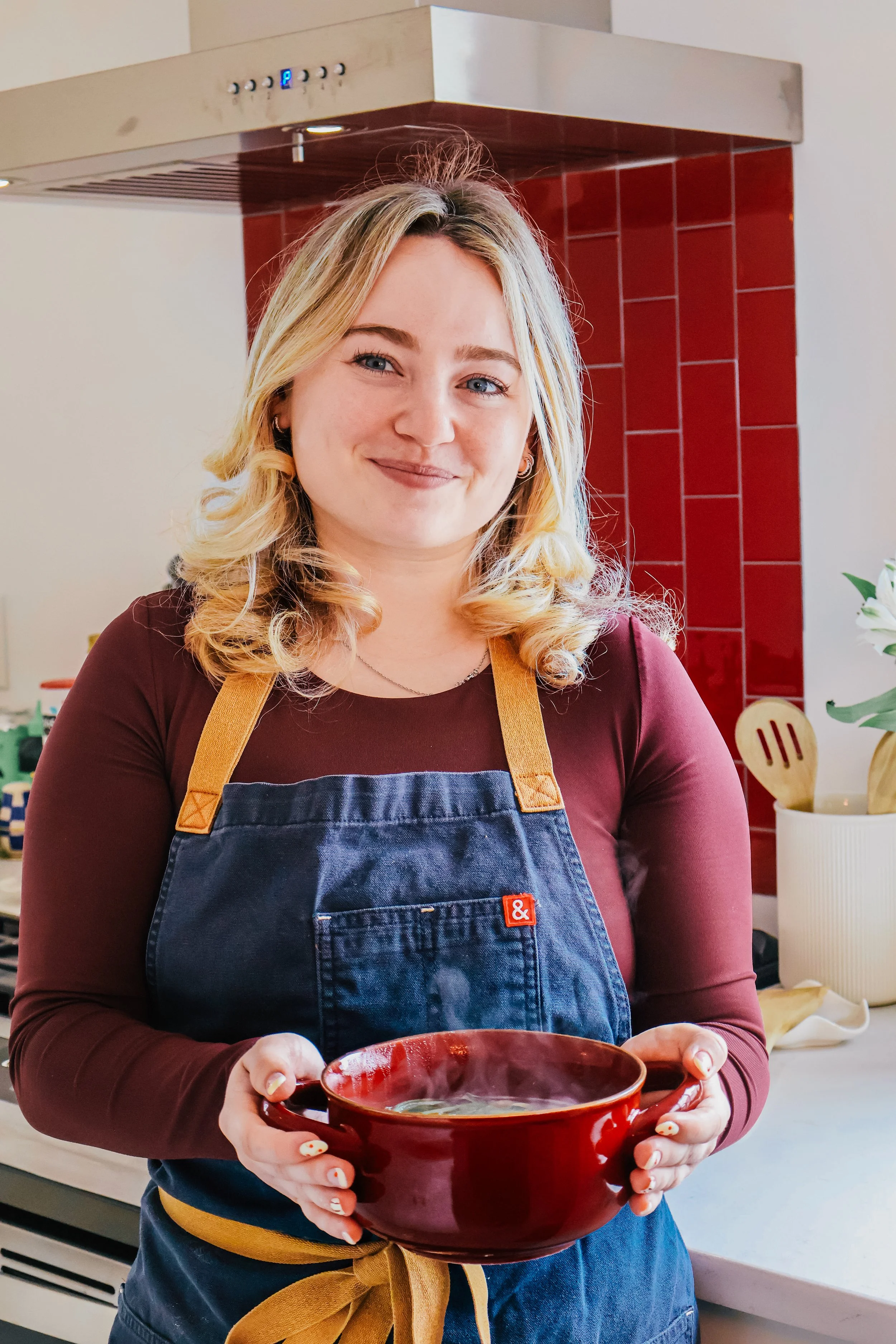 Brooke Bedell, personal chef and founder of Red Fennel Kitchen, smiling in her kitchen.
