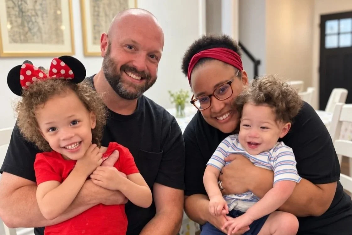 Matt Moore, a CityJoy minister who mentors struggling and suffering men, smiling alongside his wife and holding their two children.