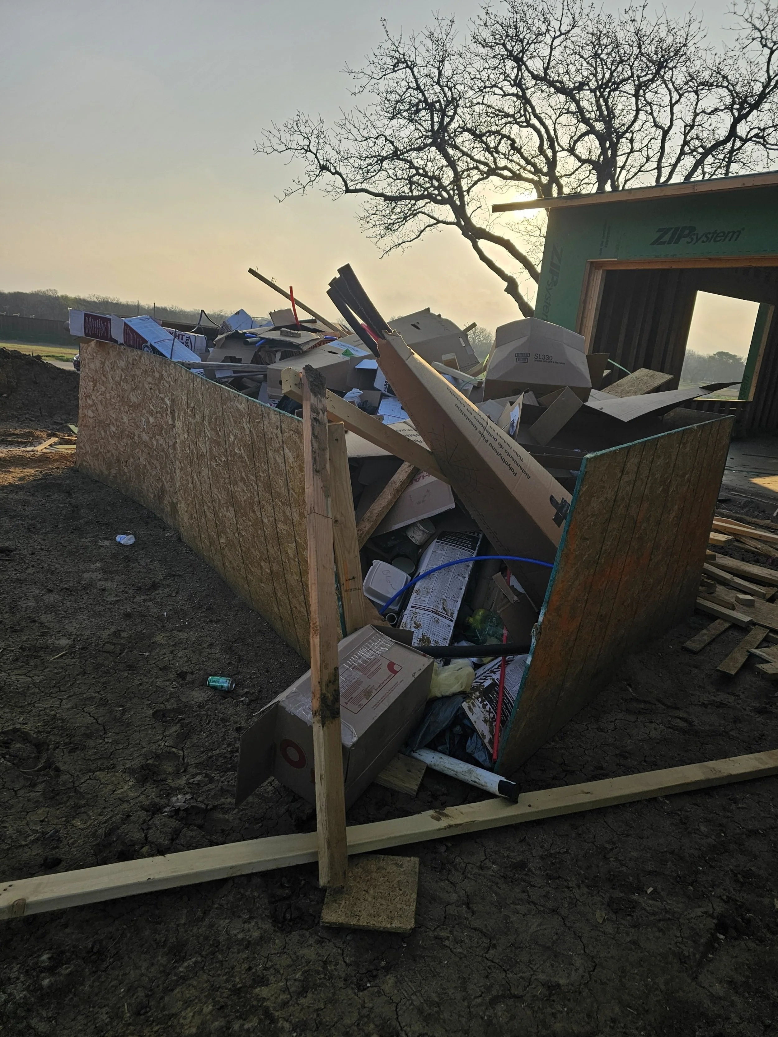 Construction Debris in a construction site getting picked up by Yellow Rose Junk Removal