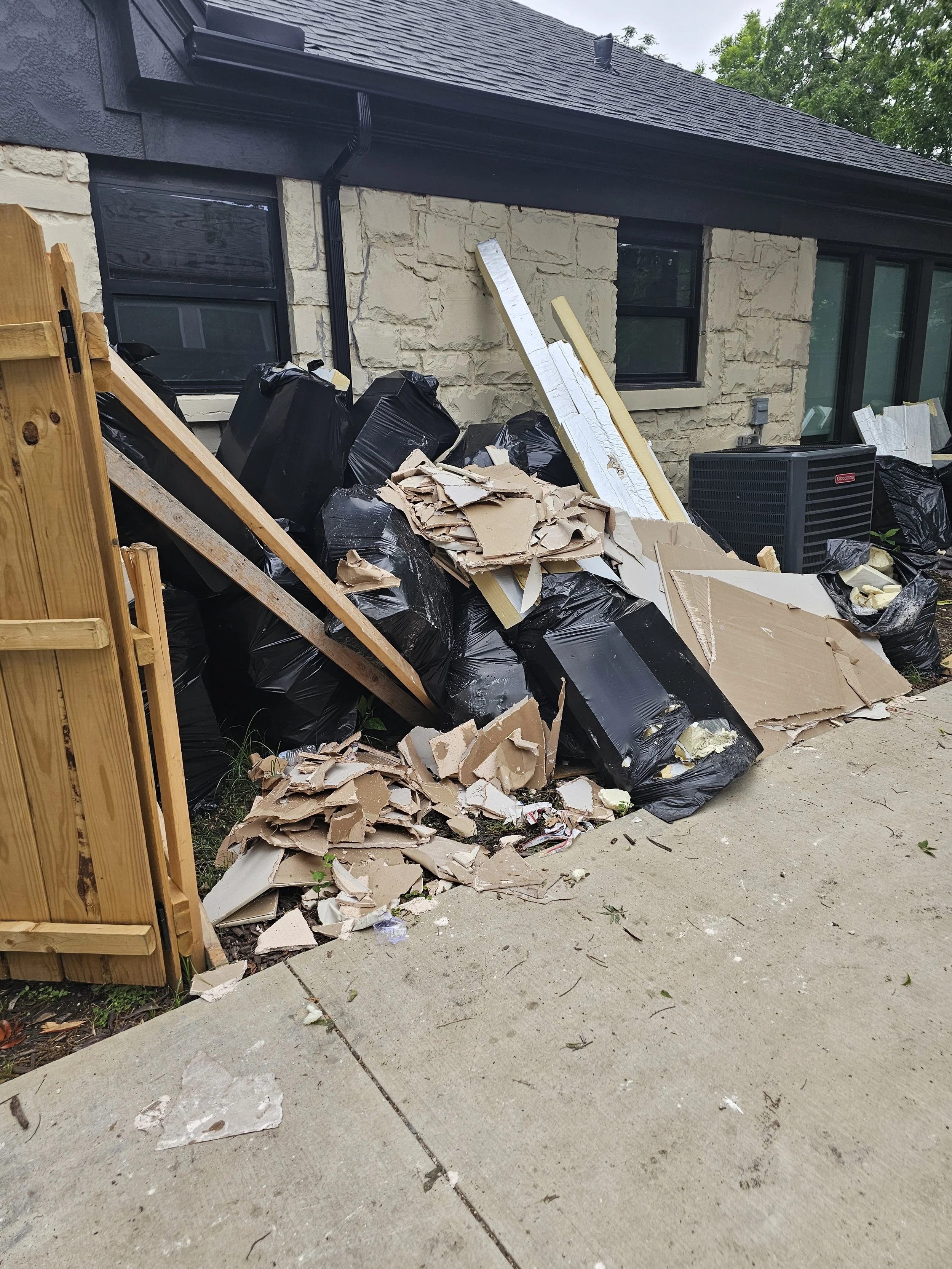 Before photo of construction debris sitting outside driveway ready to be hauled off.