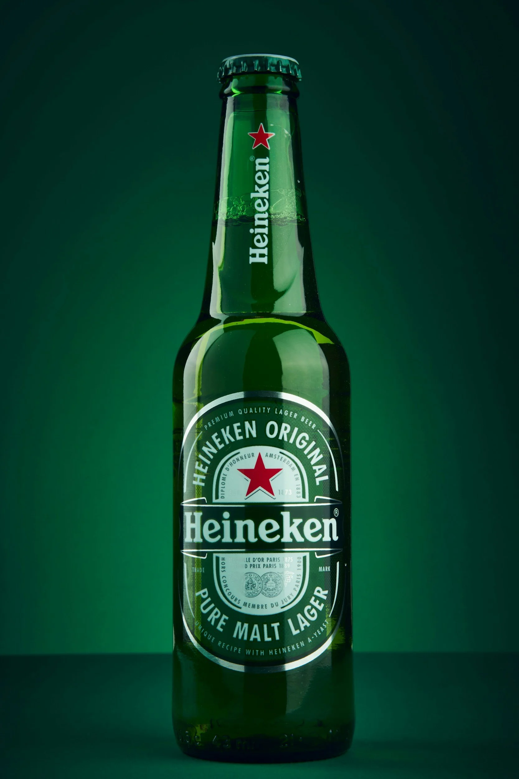 Heineken Original premium lager beer bottle against a dark green background