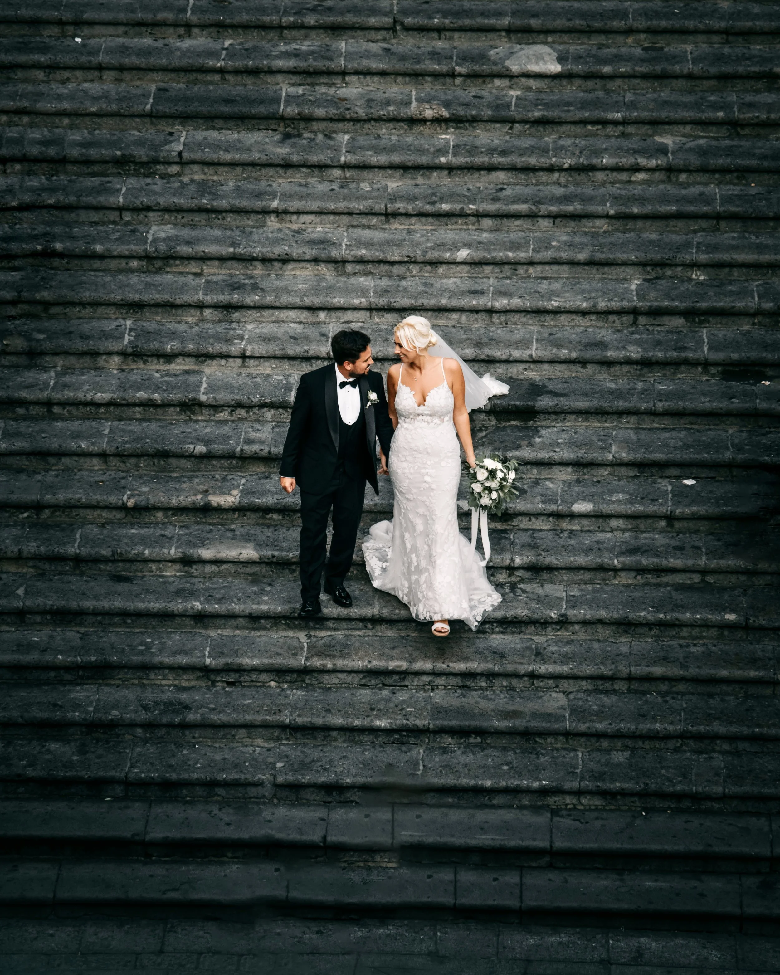 Bride and groom walking down stone steps