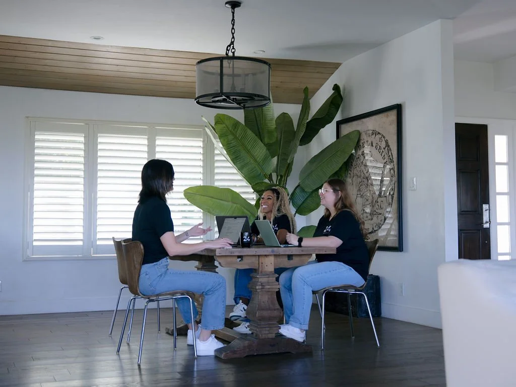 24 Sports Marketing Team meeting at a table in-person.