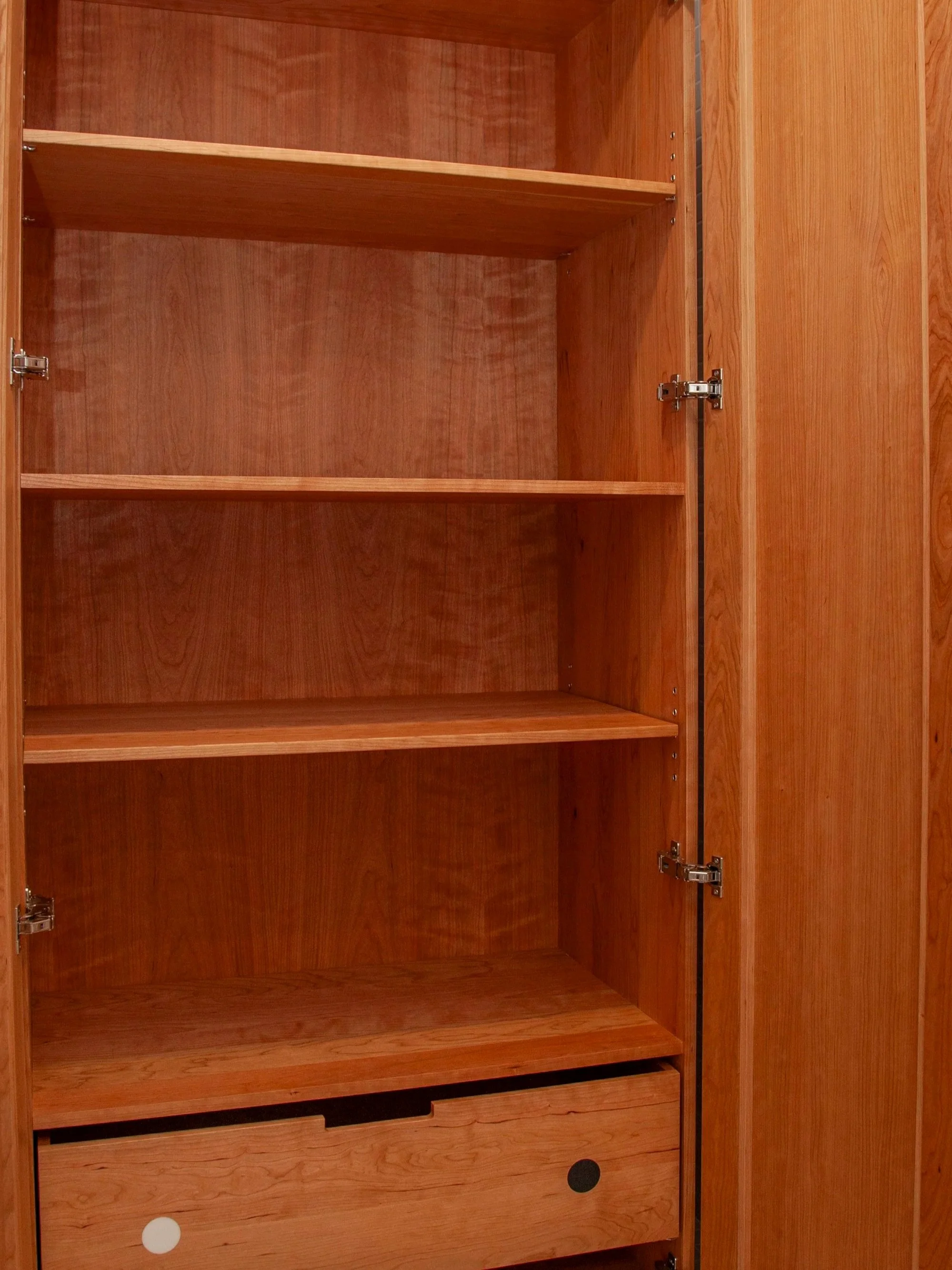 An empty wooden cabinet with open doors, four shelves, and a bottom drawer.