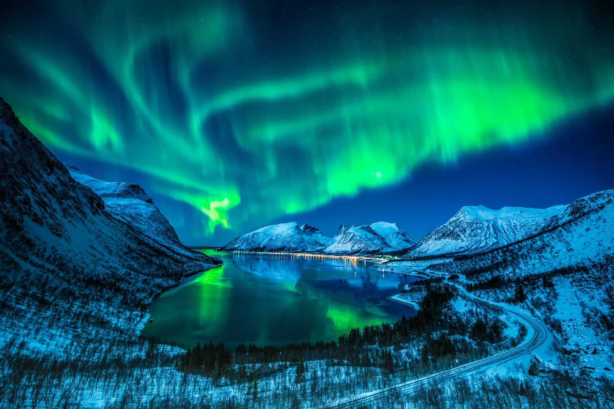 Northern lights over water and mountains of Norway