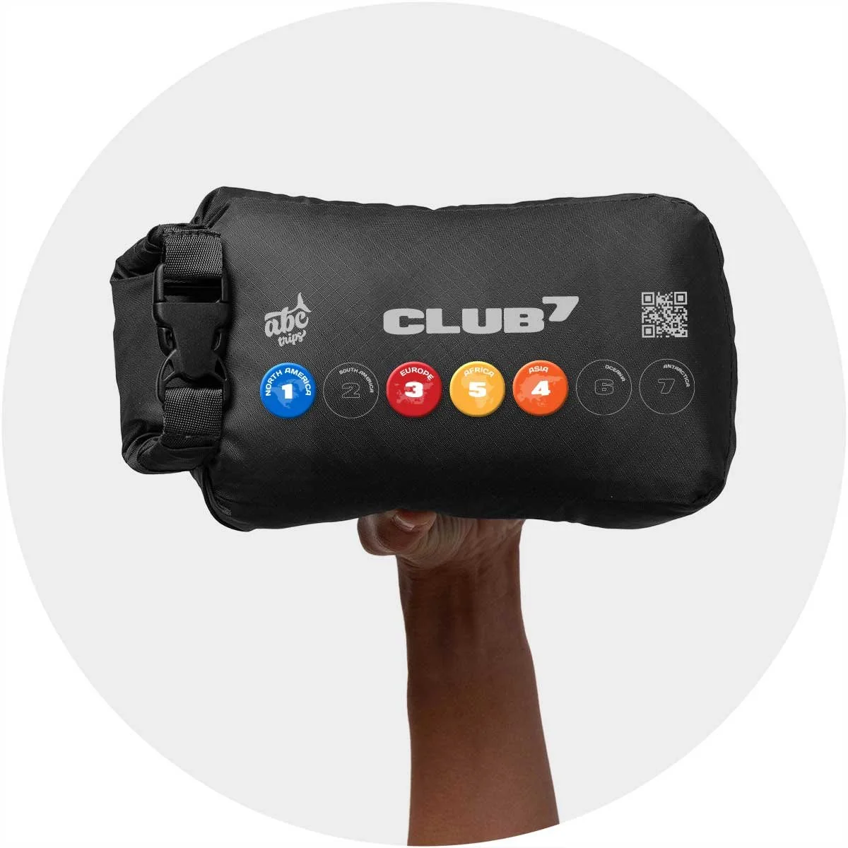 Human hand holding an ABC Trips Club⁷ travel blanket