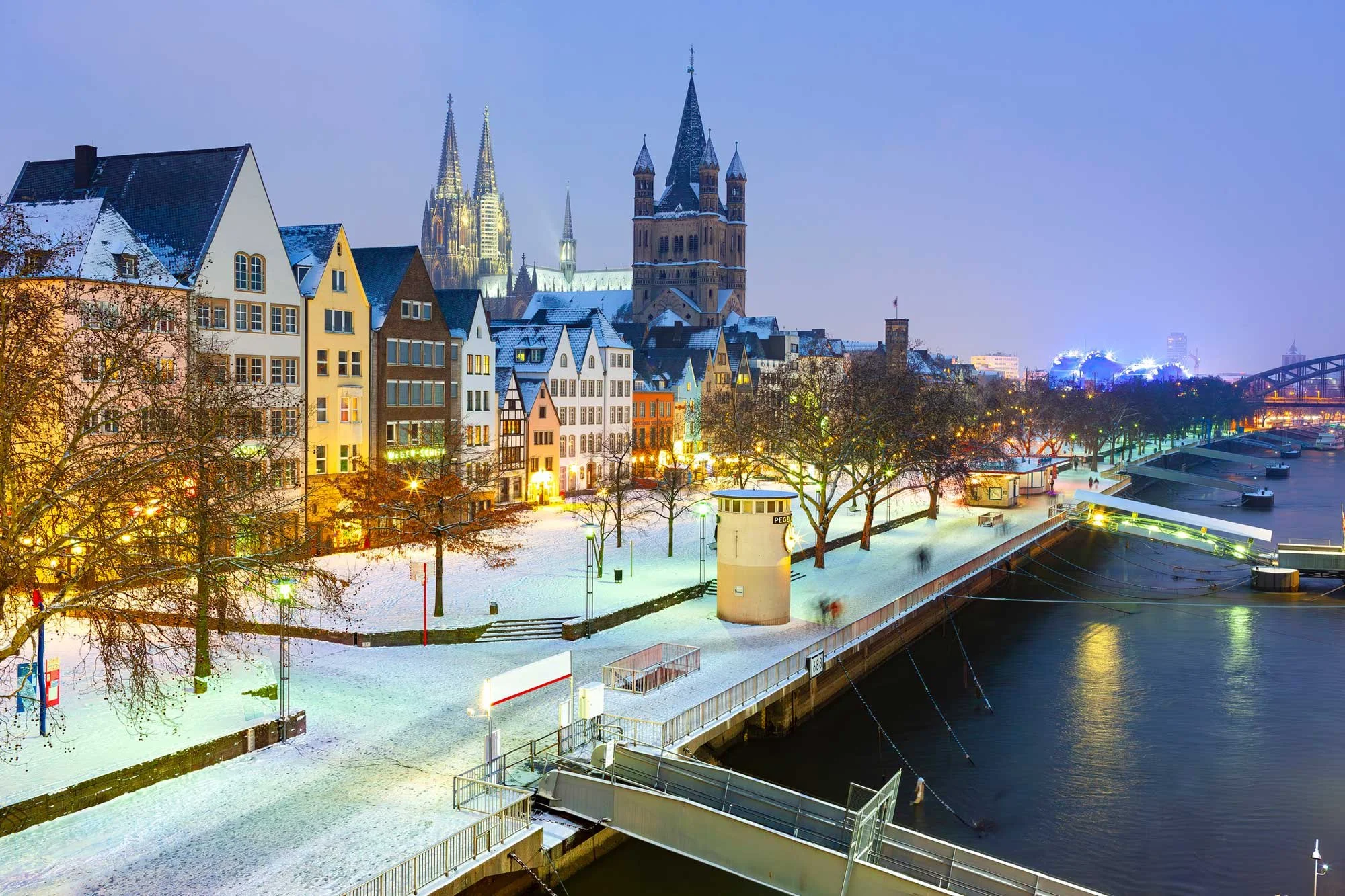 Historic buildings in Cologne's old town along the Rhine, the romanesque church of Great St. Martin and Cologne Cathedral in winter