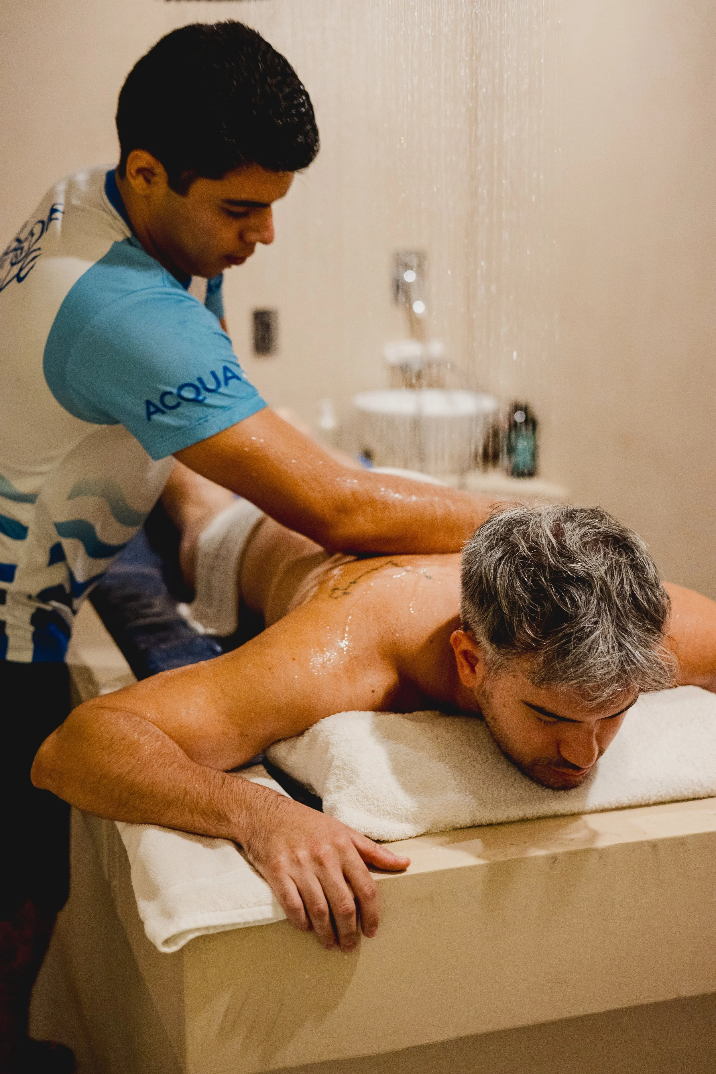A man receive a massage in a spa or wellness center while a therapist is giving him a massage.
