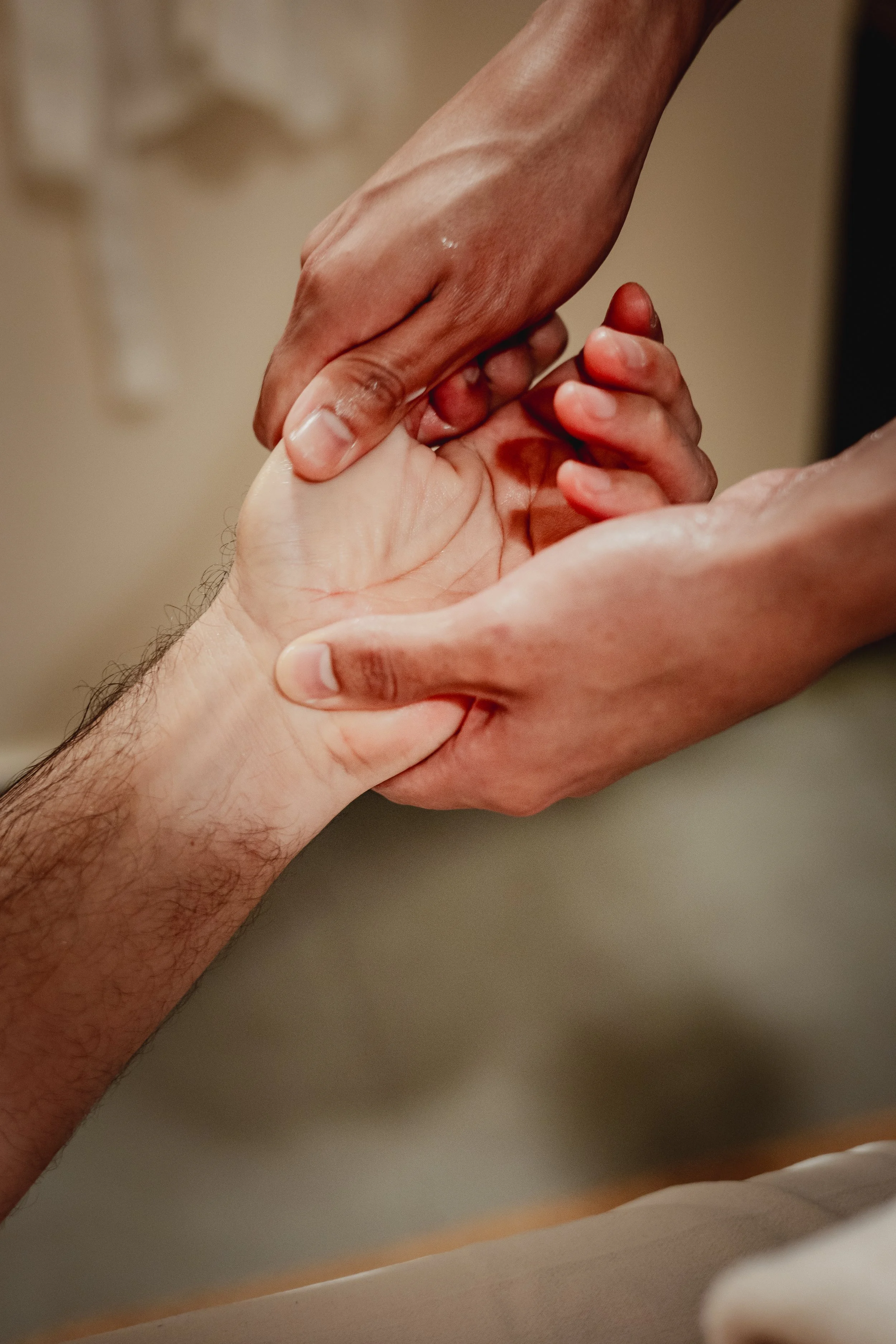 Close-up of a hand being held gently by another hand, emphasizing connection and support.