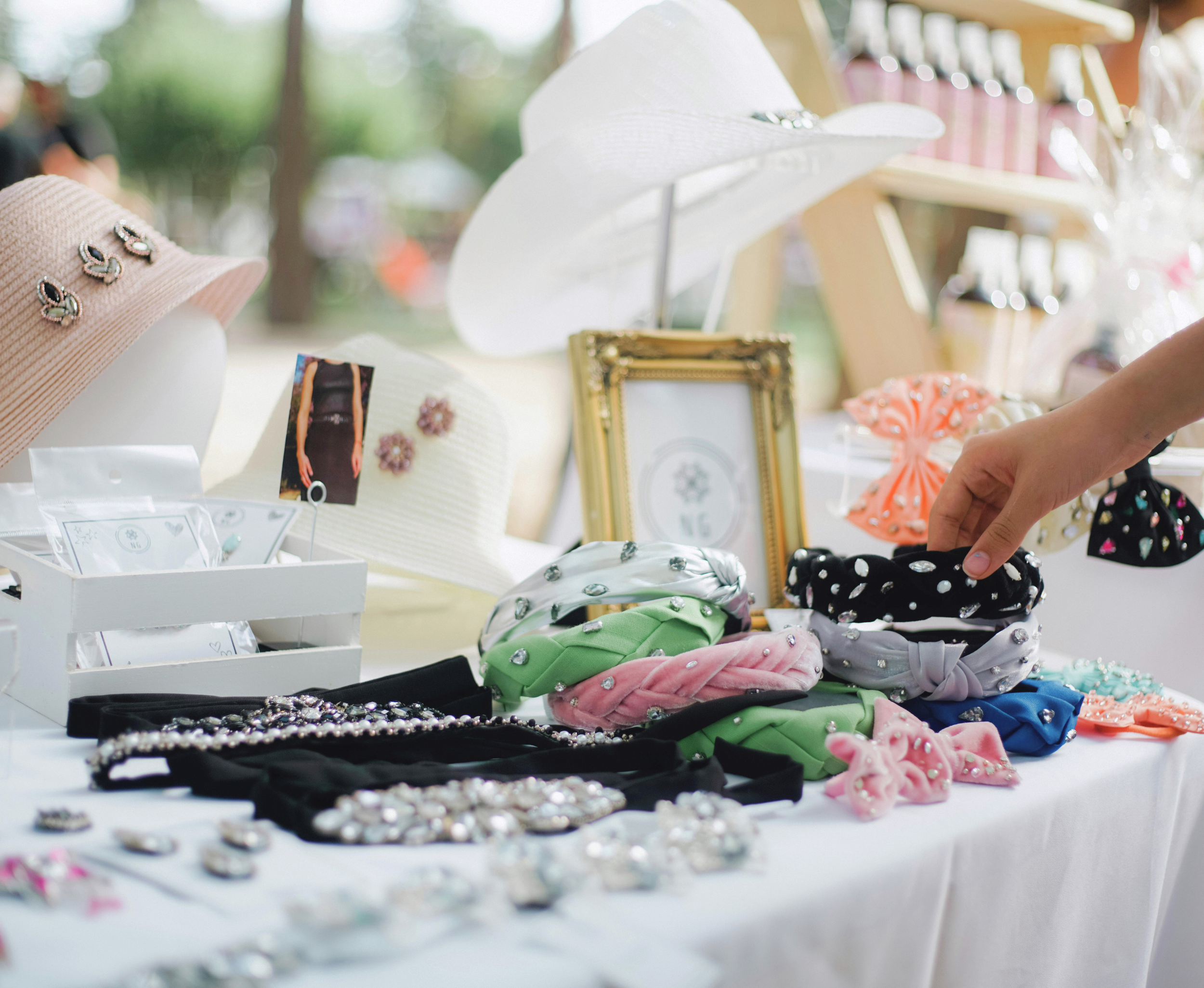 A craft table with various headbands and jewelry.