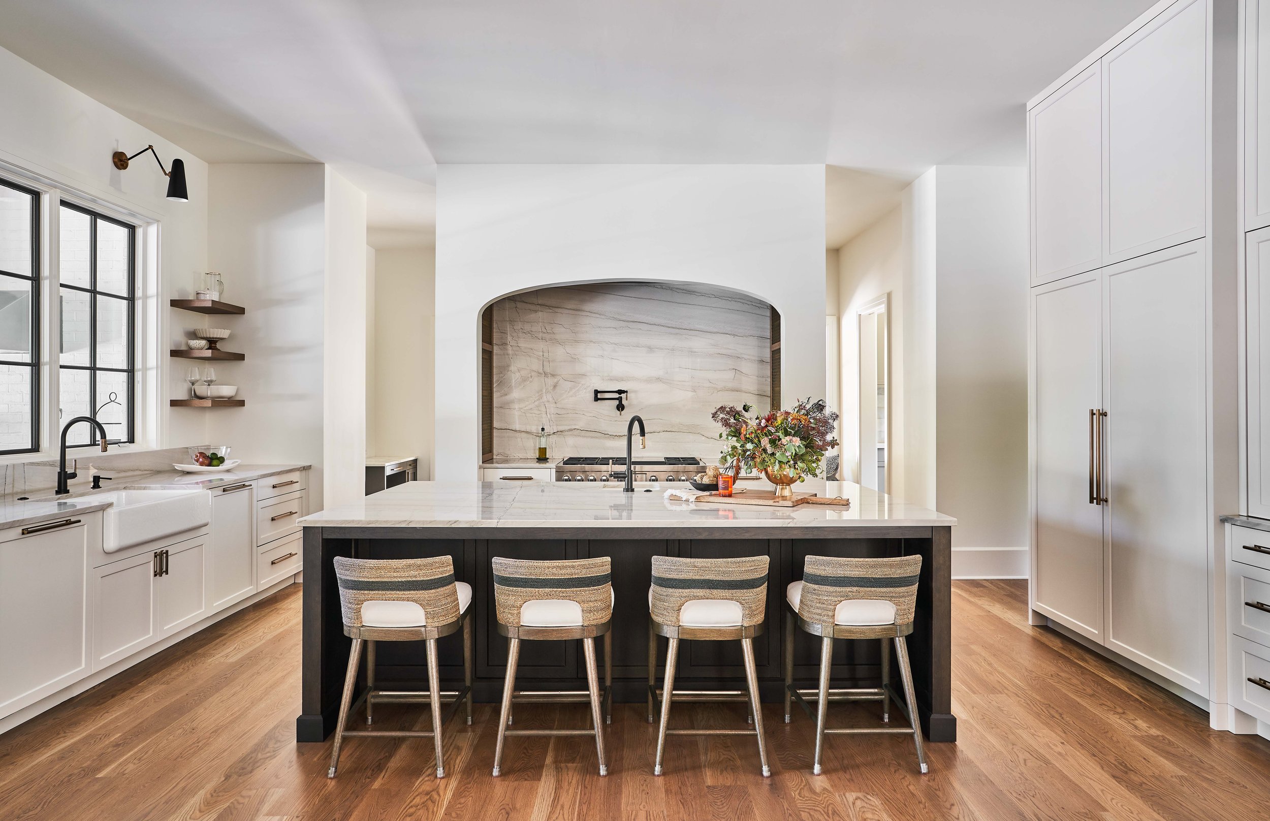 Modern kitchen with white cabinets, large island, and bar stools