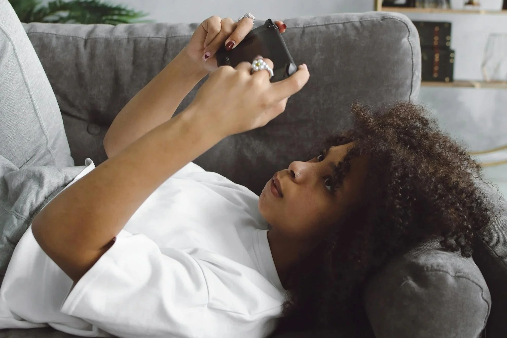Woman looking at her phone and thinking about a past relationship, reflecting emotional attachment, rejection, and difficulty letting go