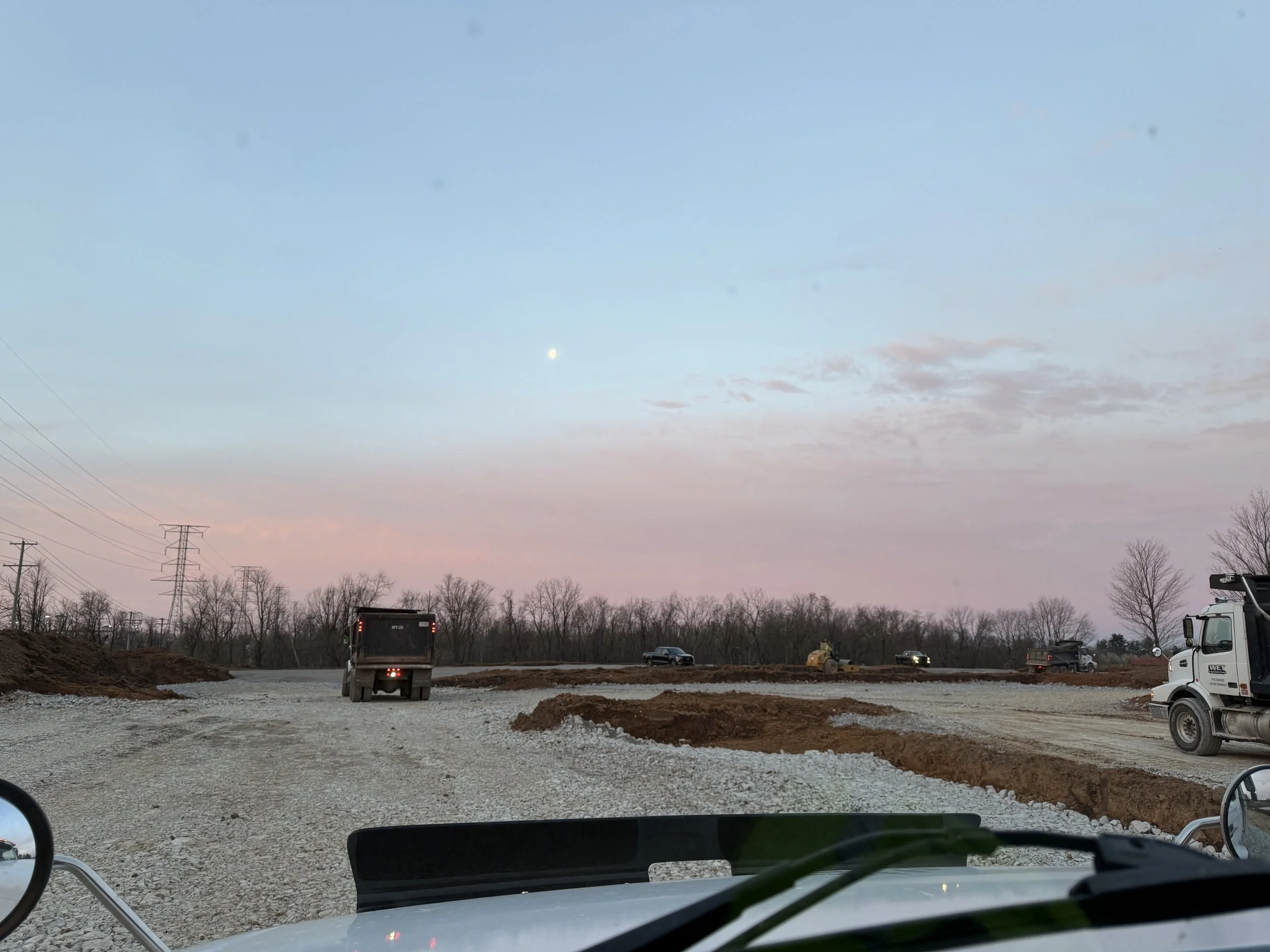 dump truck in the distance with a pink and blue sunrise