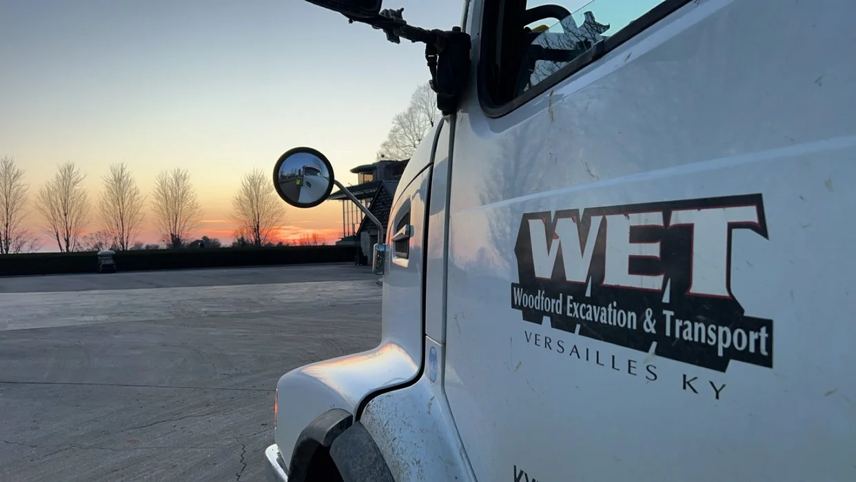WET white dump truck with sunrise in the background