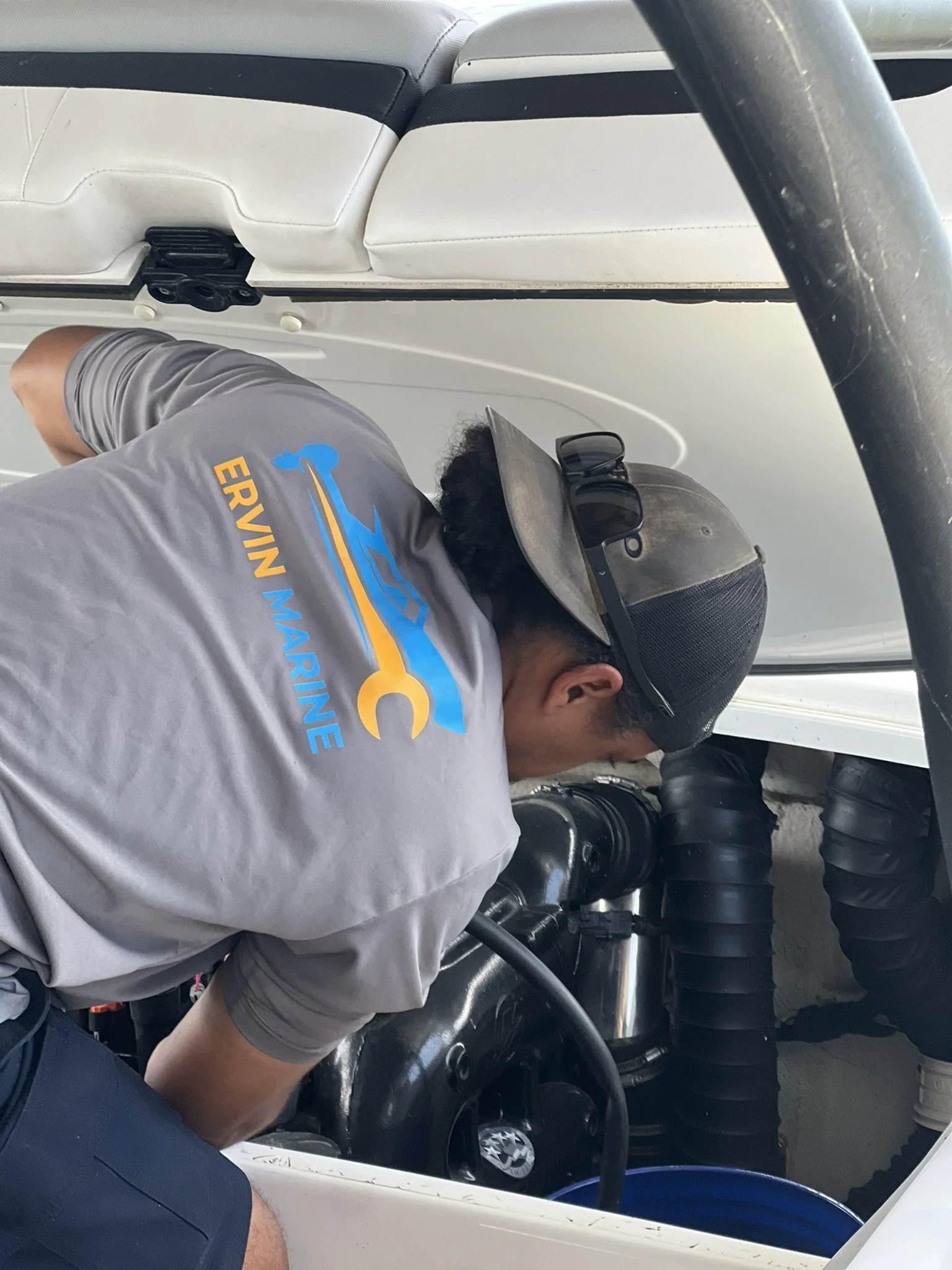 Broken red cable with frayed ends held by hands near engine compartment