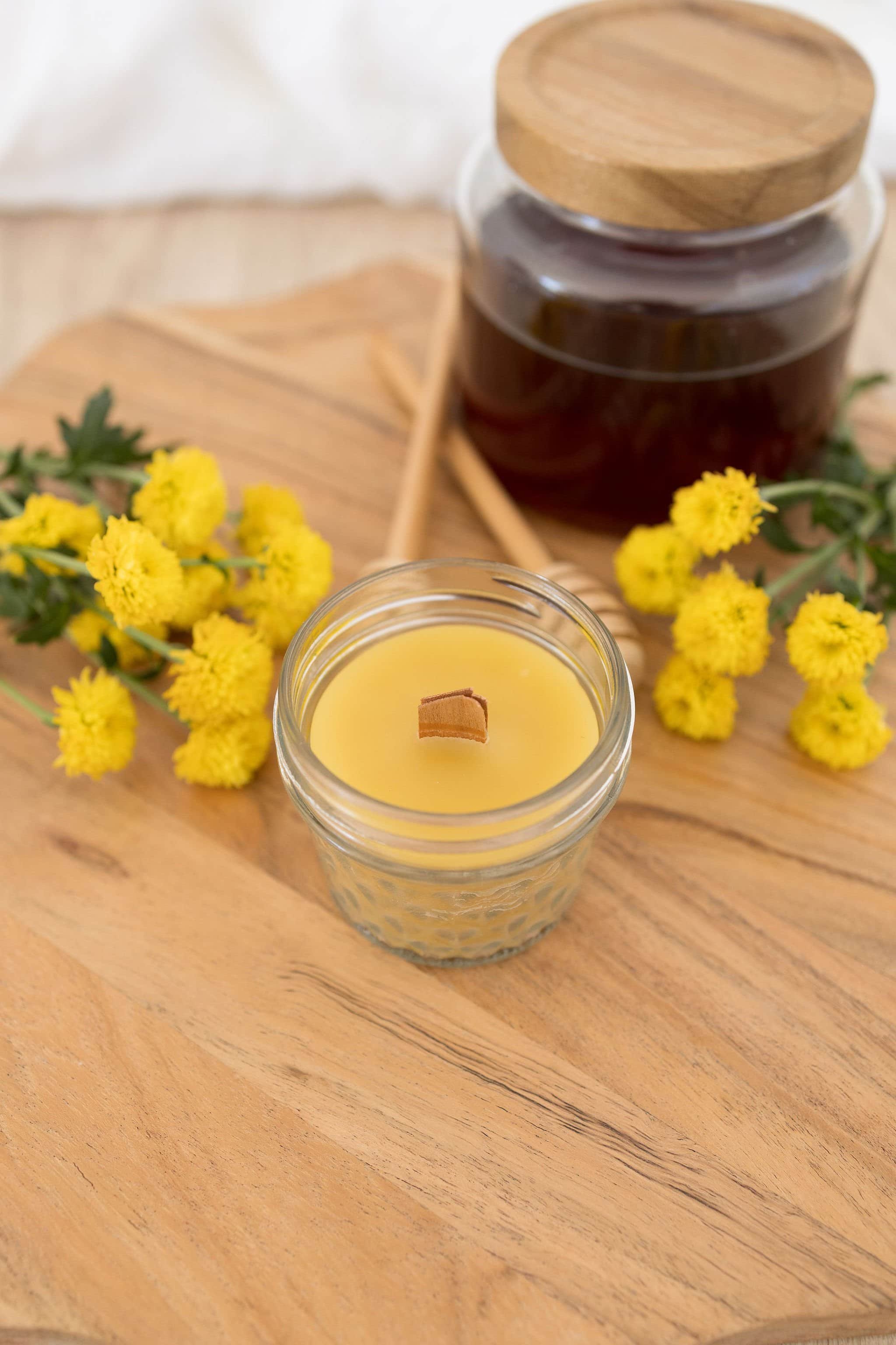 Handmade beeswax candle in glass jar with wooden wick, natural eco-luxury gift