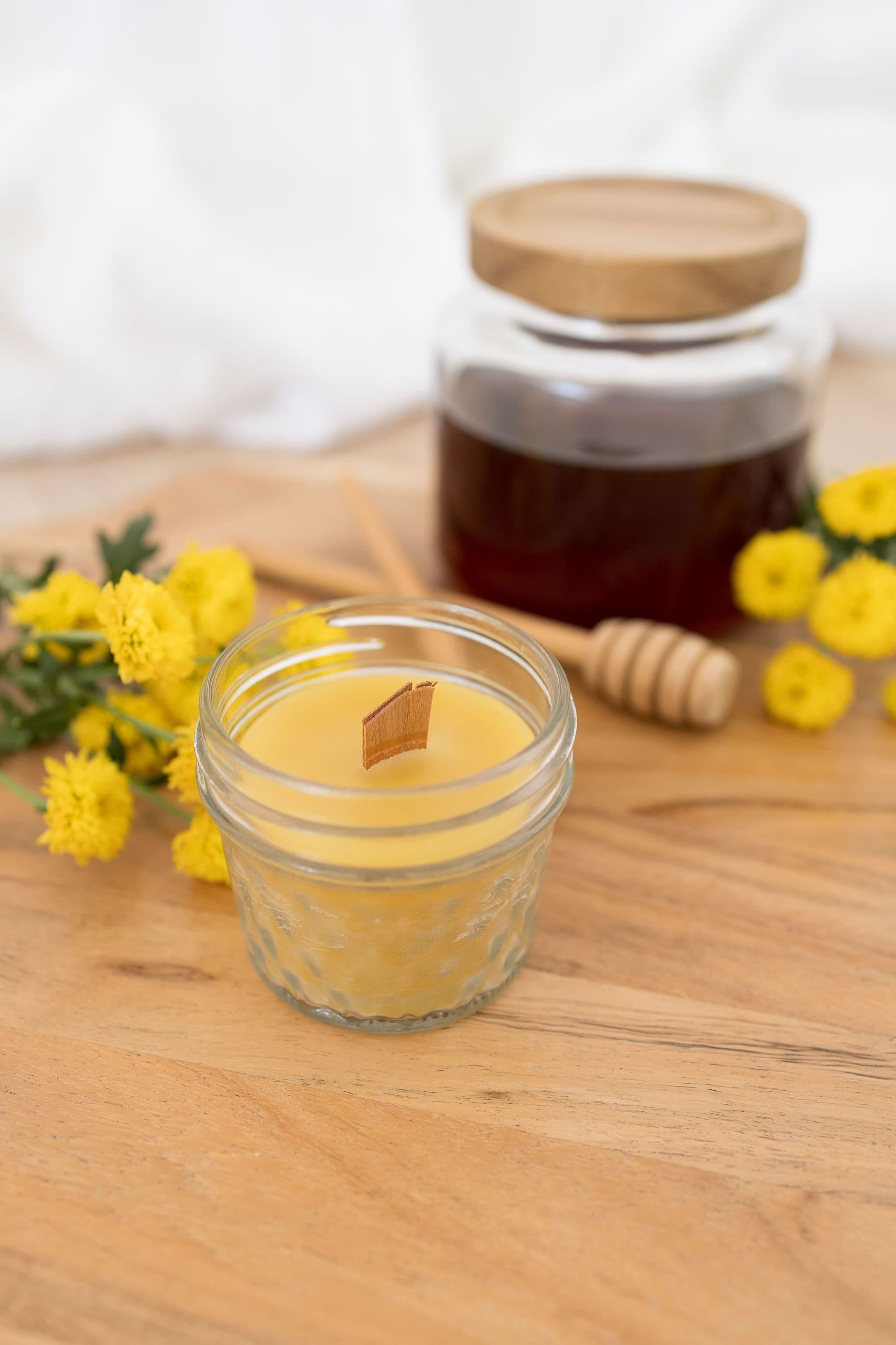 Handmade beeswax candle in glass jar with wooden wick, natural eco-luxury gift