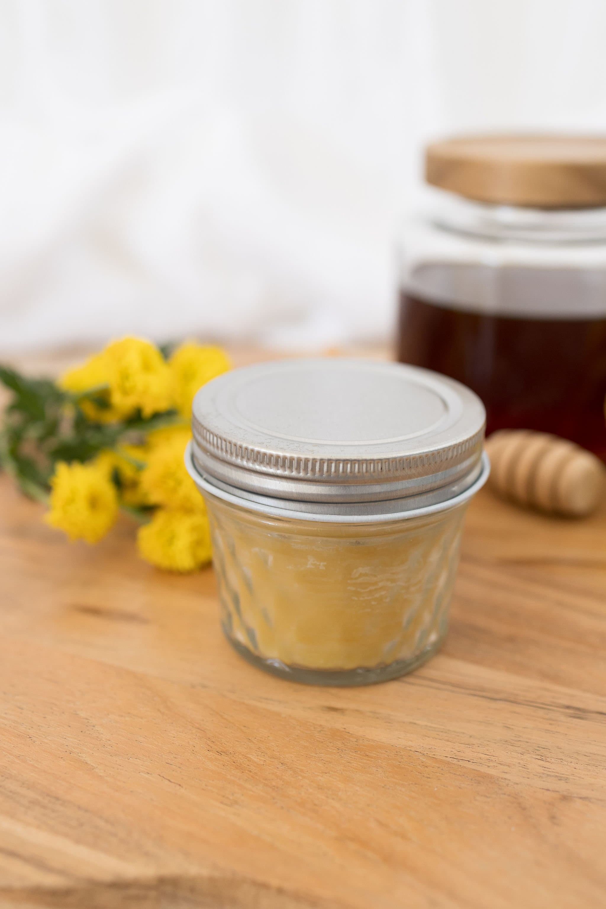 Handmade beeswax candle in glass jar with wooden wick, natural eco-luxury gift