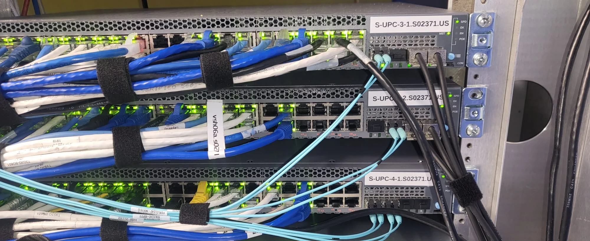 Close-up of a server rack with network switches and numerous Ethernet cables organized with cable ties.