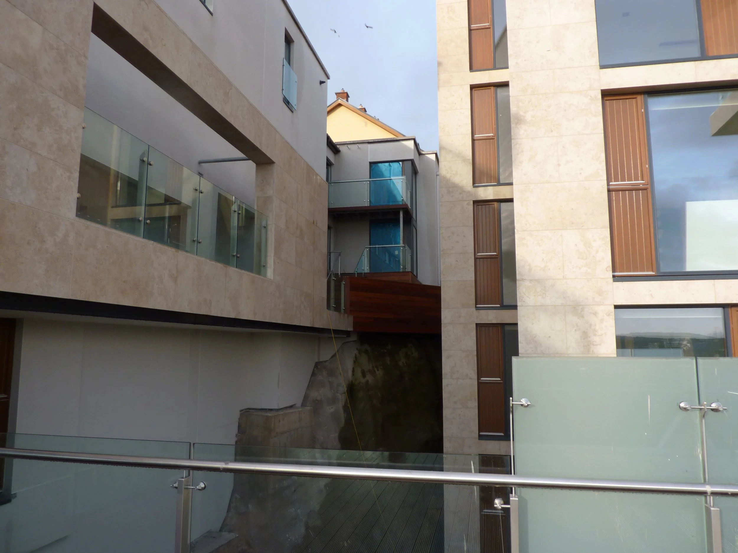 modern building exterior with beige stone and glass balconies