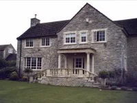 Stone house with a front porch and manicured lawn