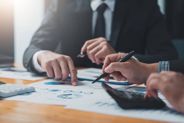 Two business professionals reviewing documents and financial charts