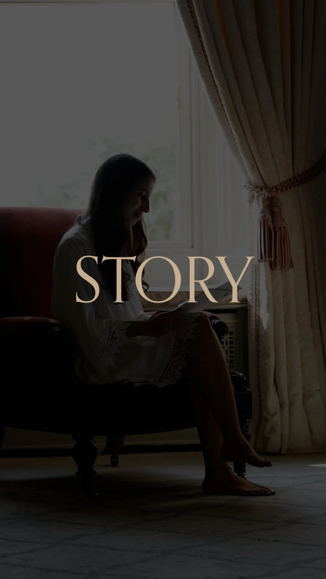 A woman sitting on a chair by a window, reading a book, with long hair, dressed in a white outfit, in a room with draped curtains and a radiator visible. The word 'STORY' overlayed on the image.