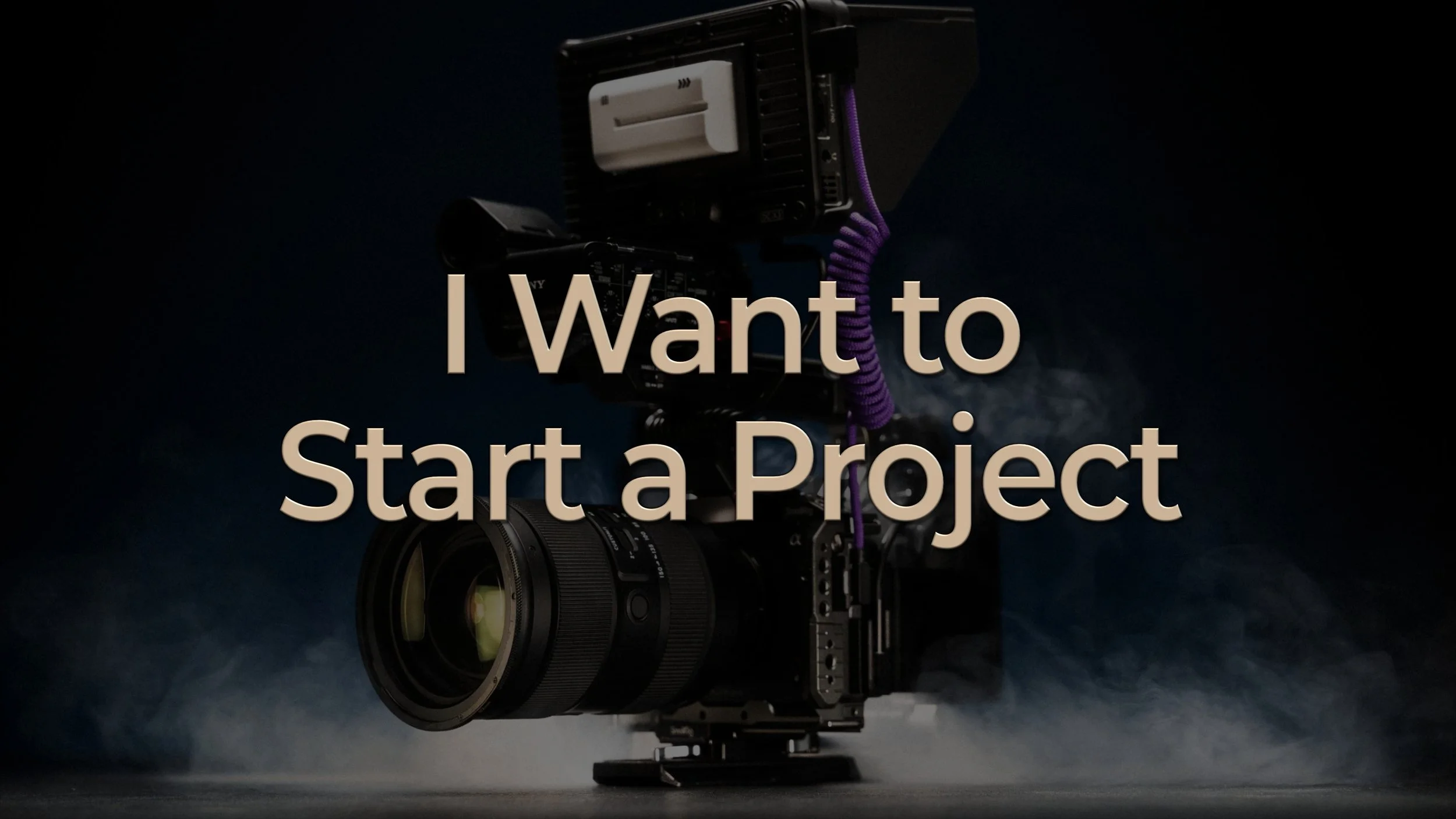 Image of camera with an attached lens, camera monitor surrounded by smoke on a dark background. Overlay text reads "I Want to Start a Project"