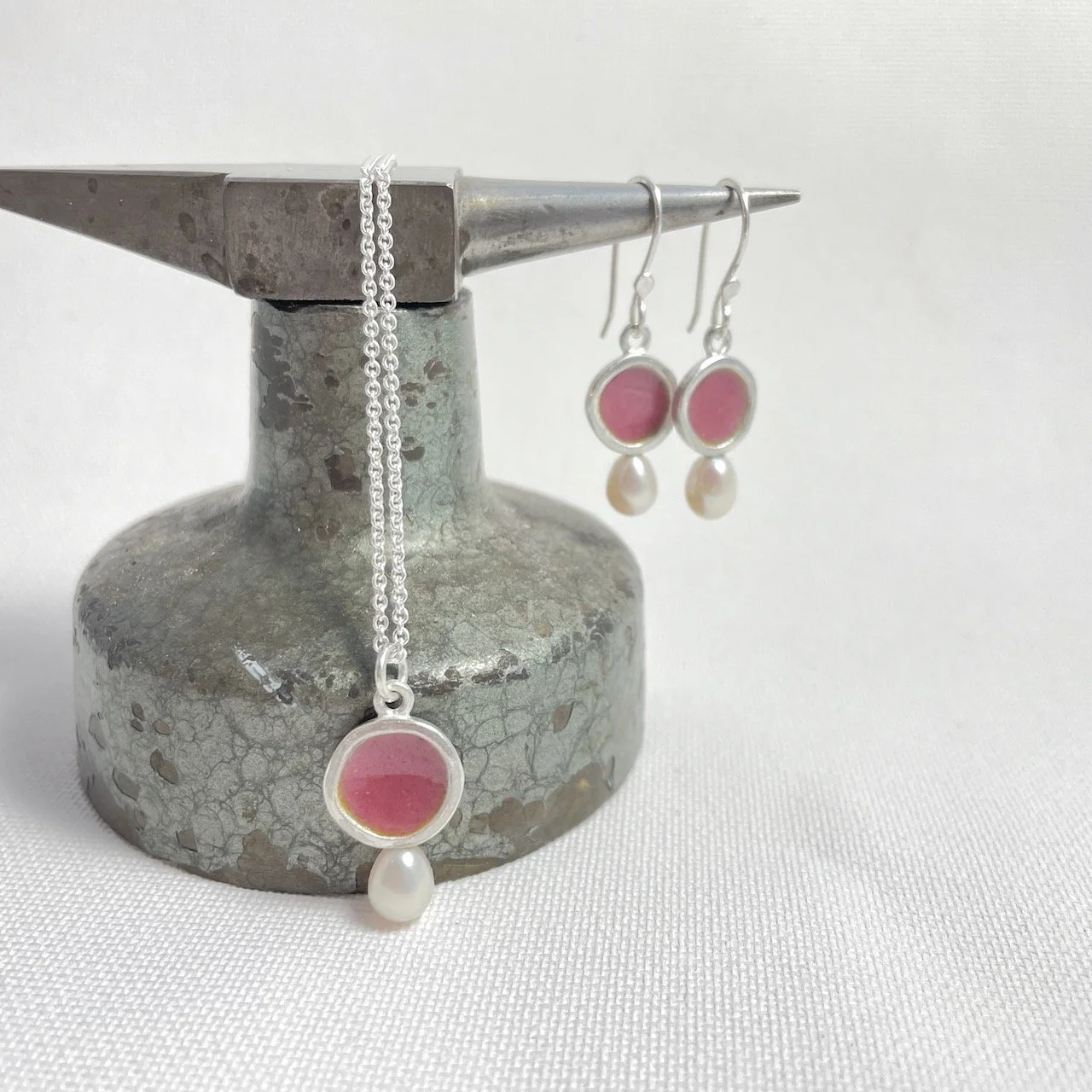 Anhänger: Coral-Rosa, Schälchen 13 mm mit Perle. 145,- zzlg. Kette 25,-.
Ohrringe Schälchen 11 mm, Paar 275,-