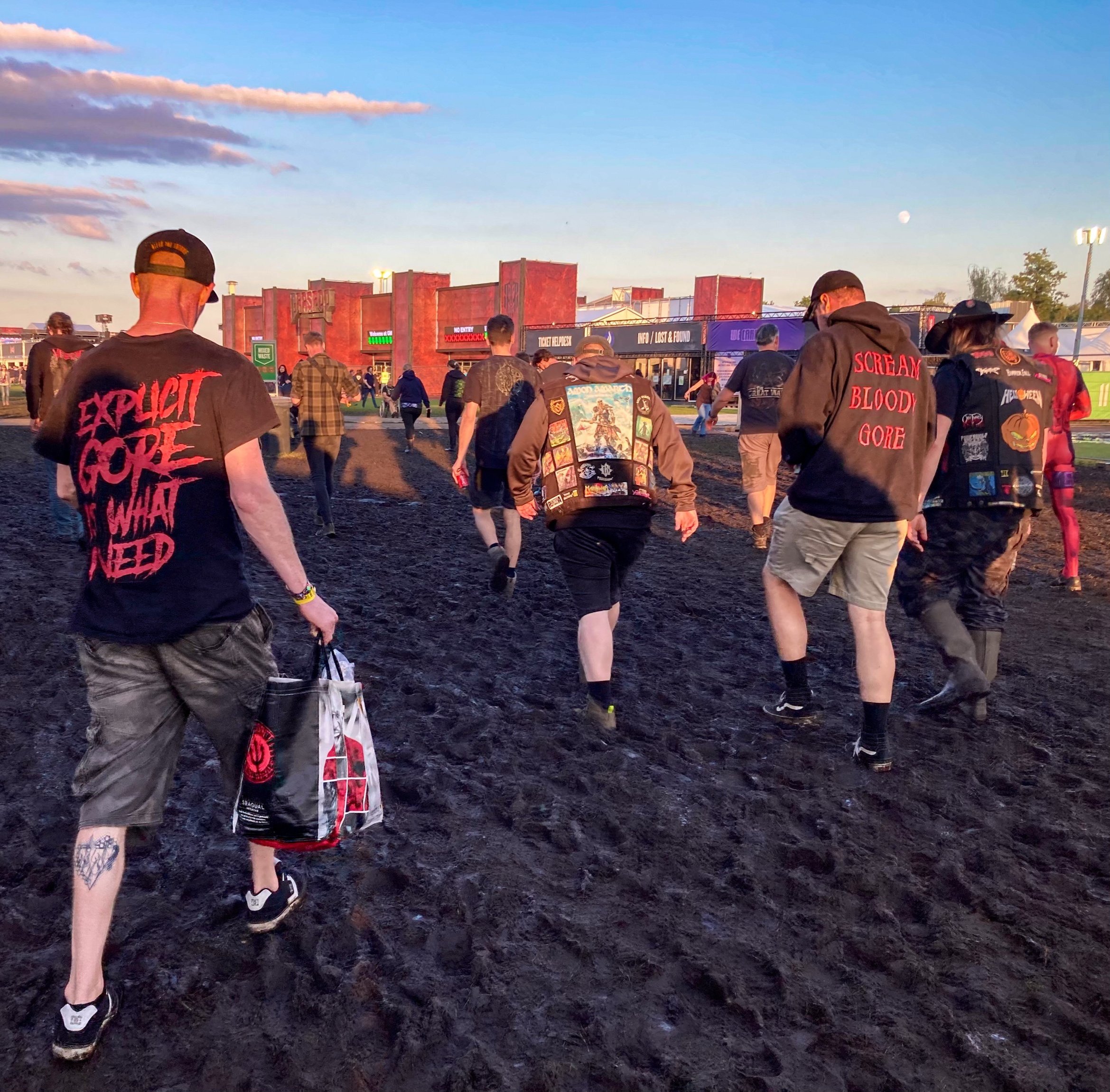 Open air music festival Graspop Metal Meeting GMM GMM24 metalheads walking through mud rubber boots extreme weather