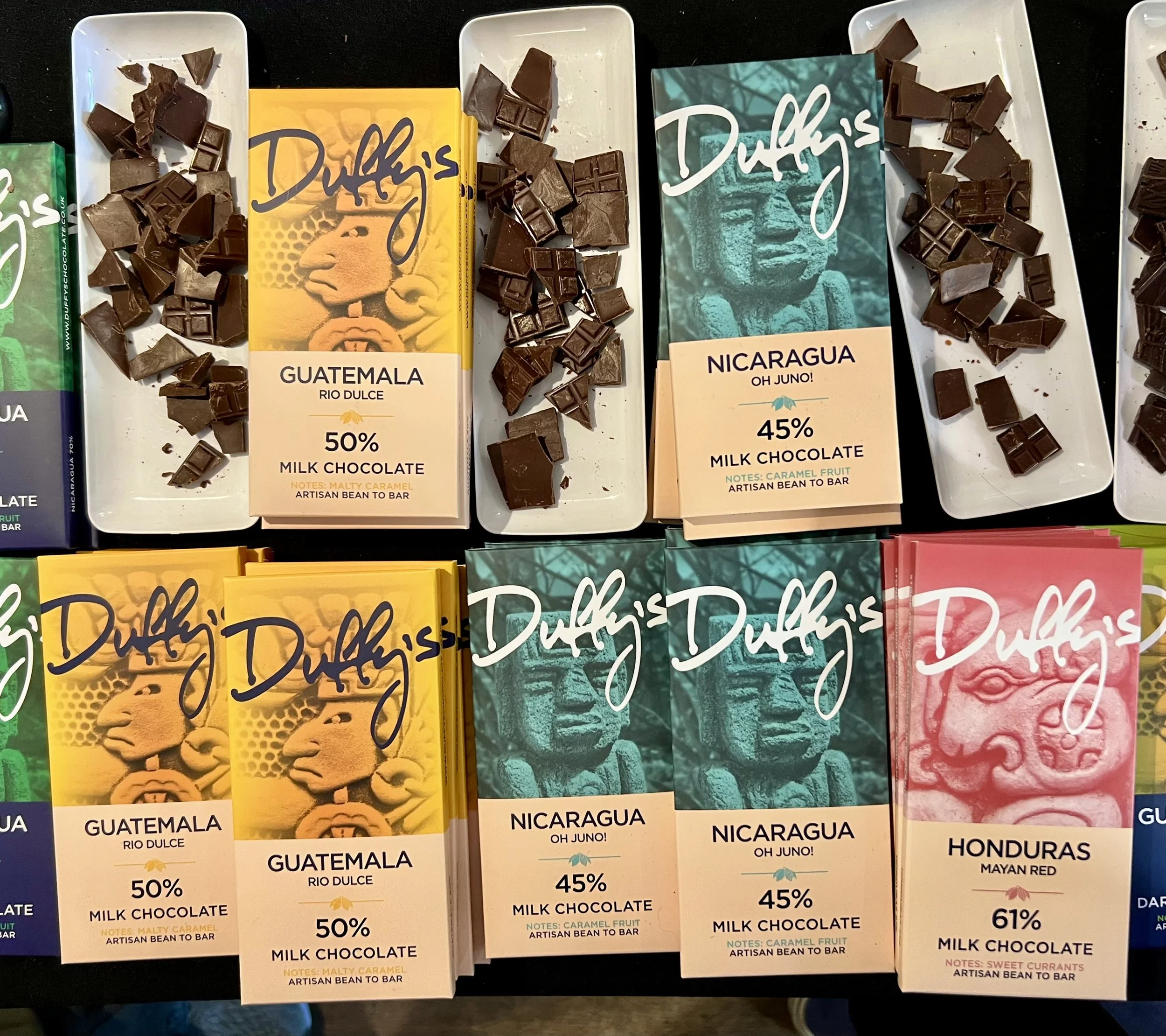 Bars of Duffy's craft dark milk chocolate - the packaging and pieces of chocolate on a plate.