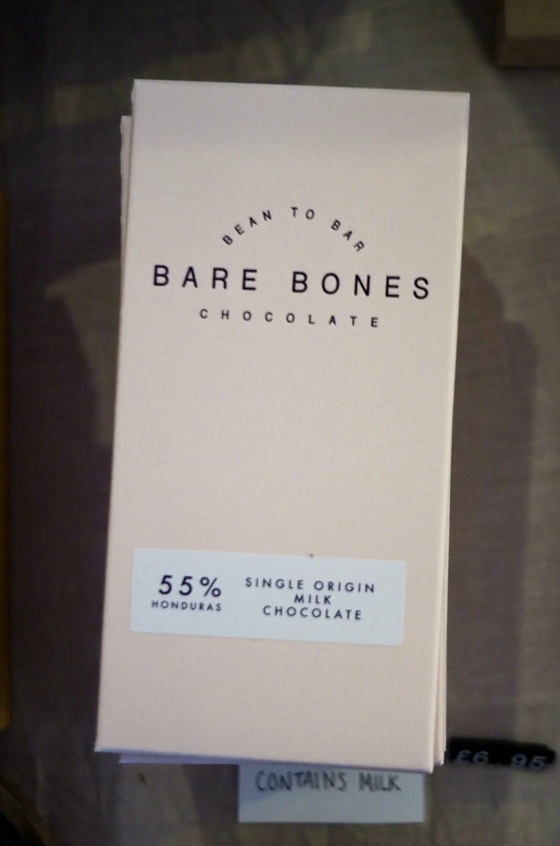 Bare Bones dark milk chocolate bars in a beige packaging on a table
