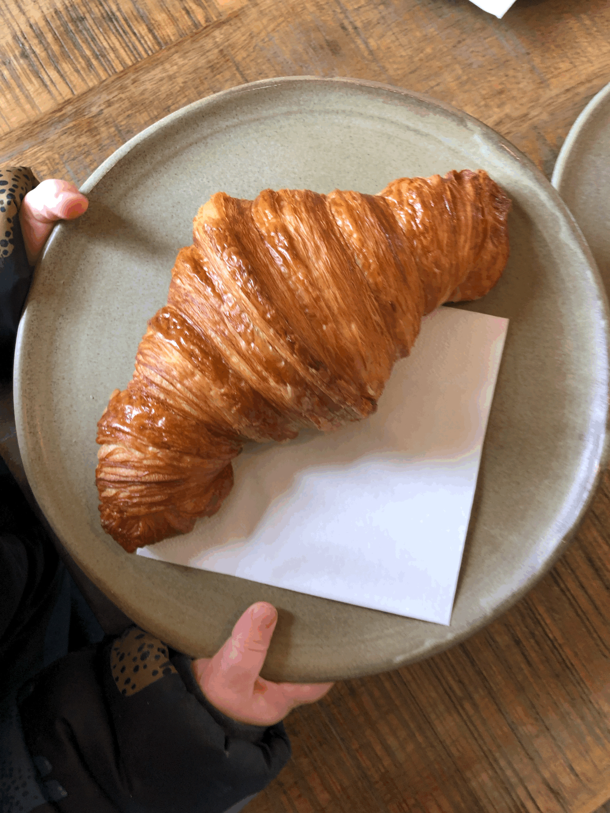 Giant croissant on a plate to share the 2026 London Croissant Map.