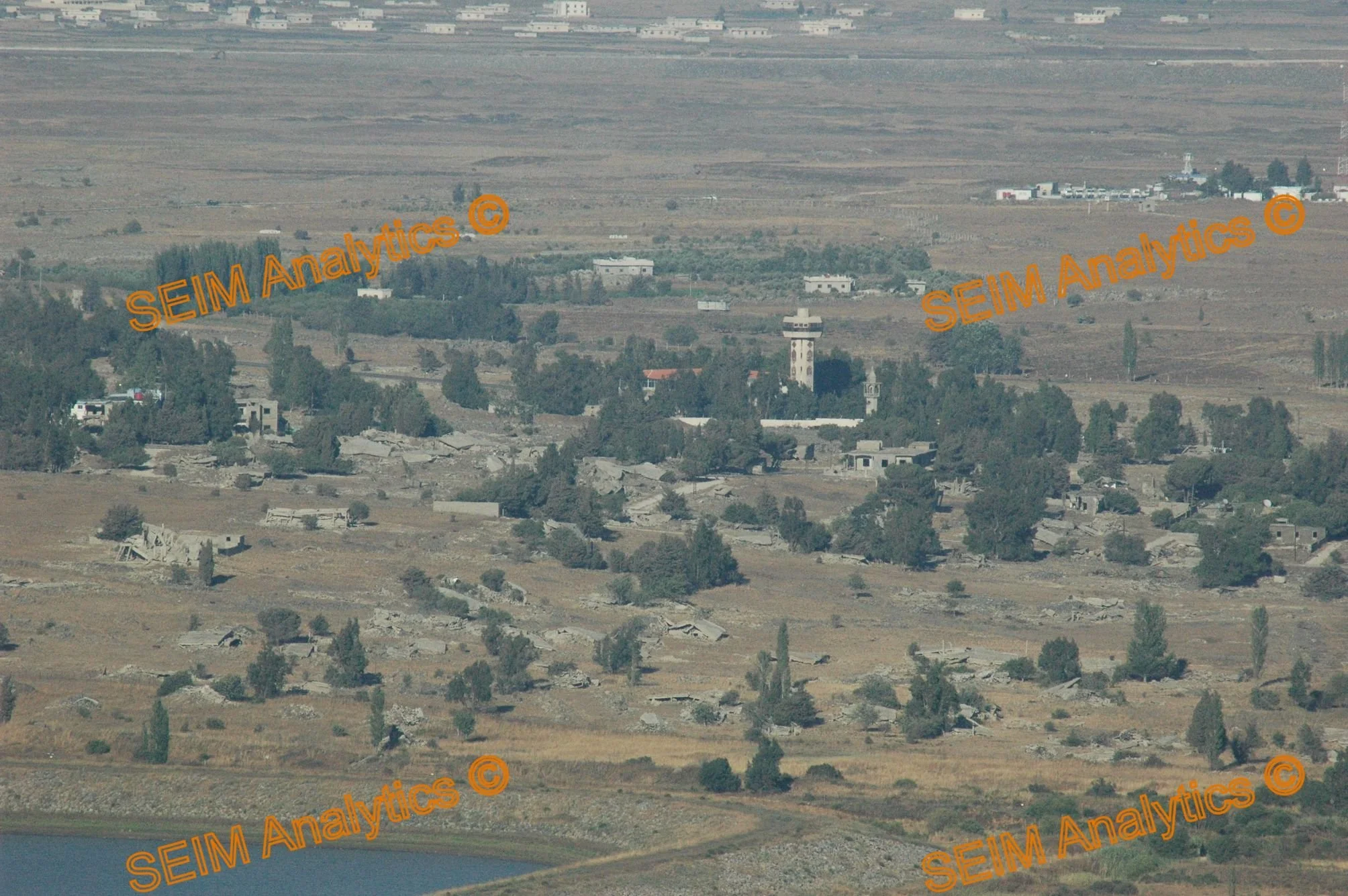Golan Hights, view from Majdal Shams towards Syrian Quneitra. Destroyed housing by observation tower, new housing further behind on Syrian territory (2008).