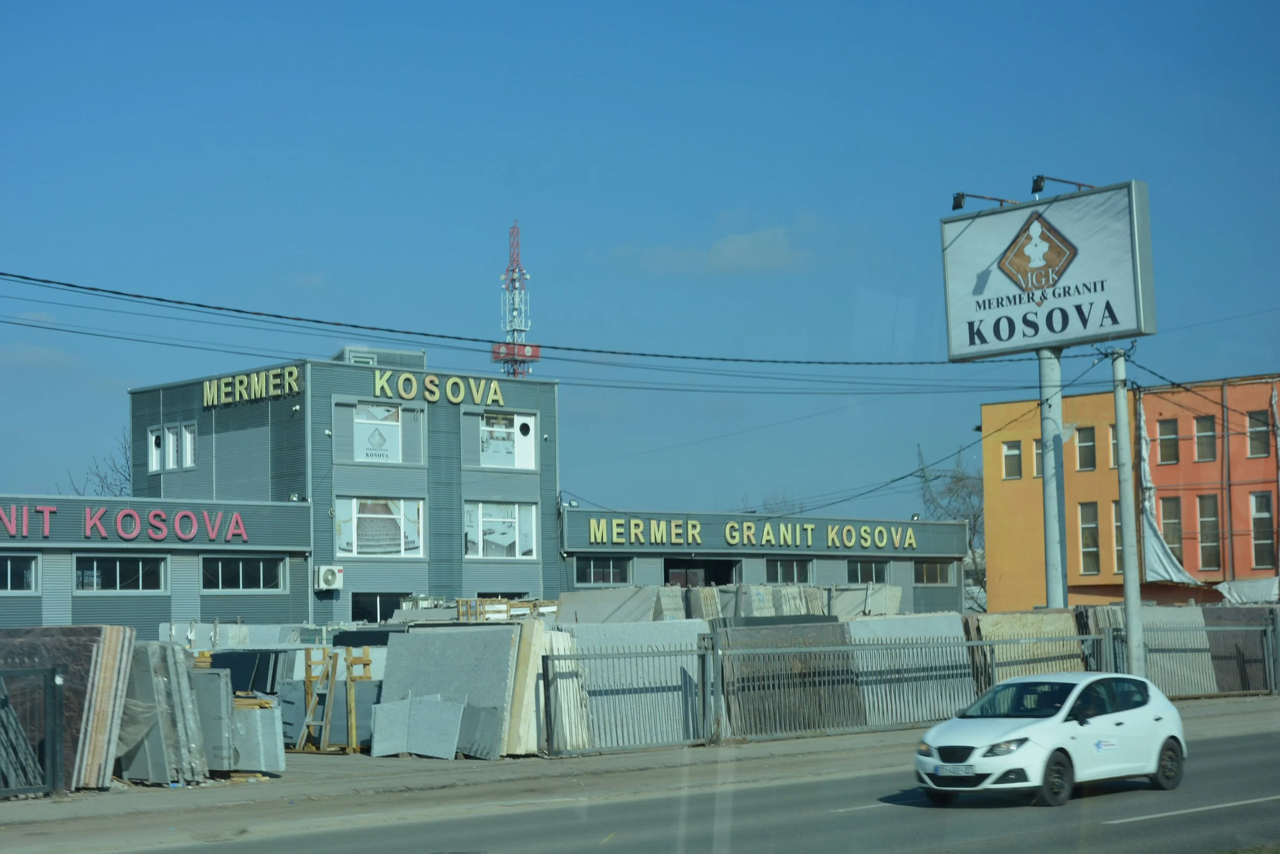 Kosovo 2025: A commercial building with signage that reads 'Mermer Kosova' and 'Mermer Granit Kosova', indicating it specializes in marble and granite.
