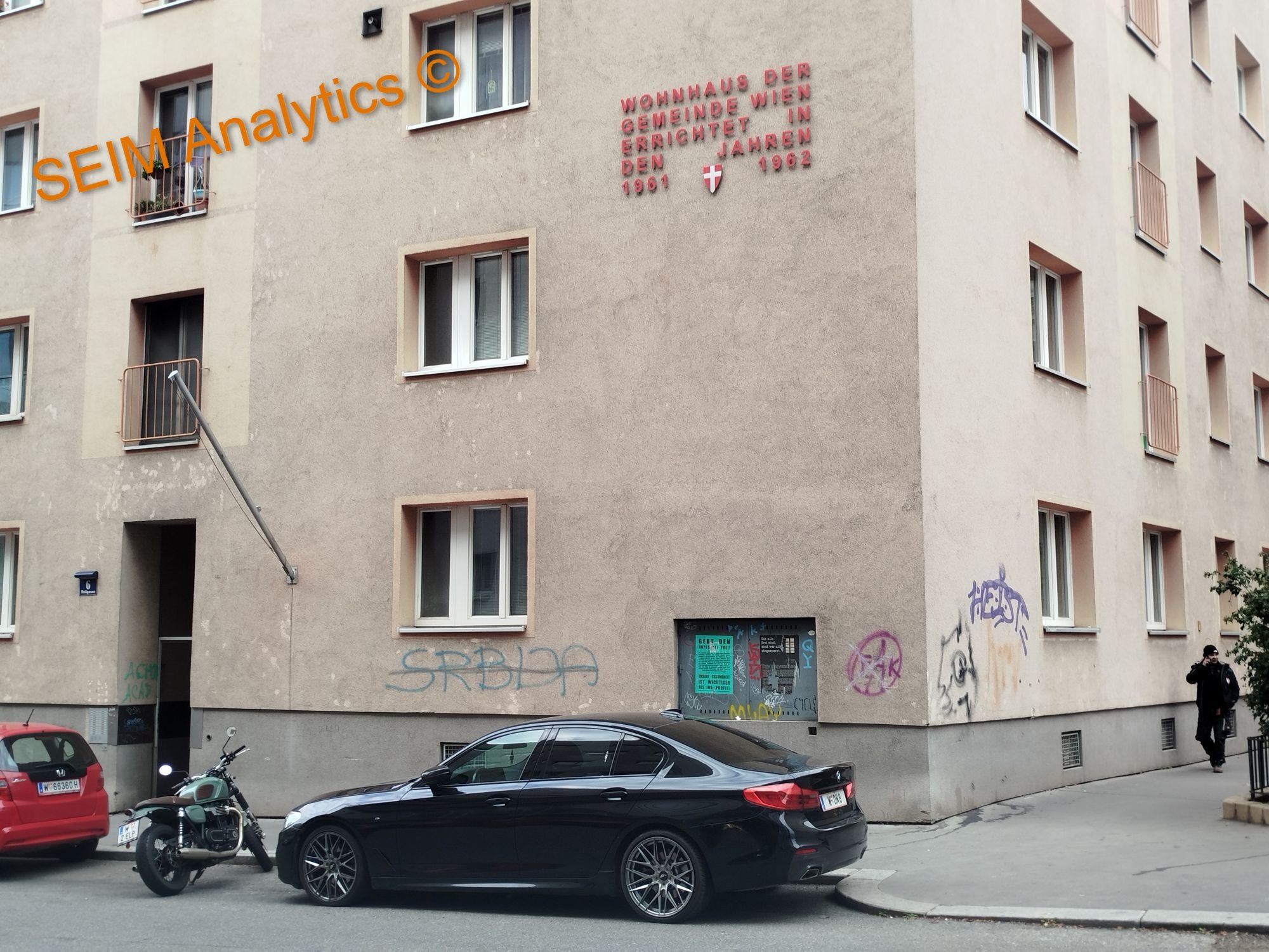 Social housing in Vienna's 5th district, by Matzleinsdorferplatz. A beige apartment building with graffiti and a red sign on the wall saying 'Serbia'.