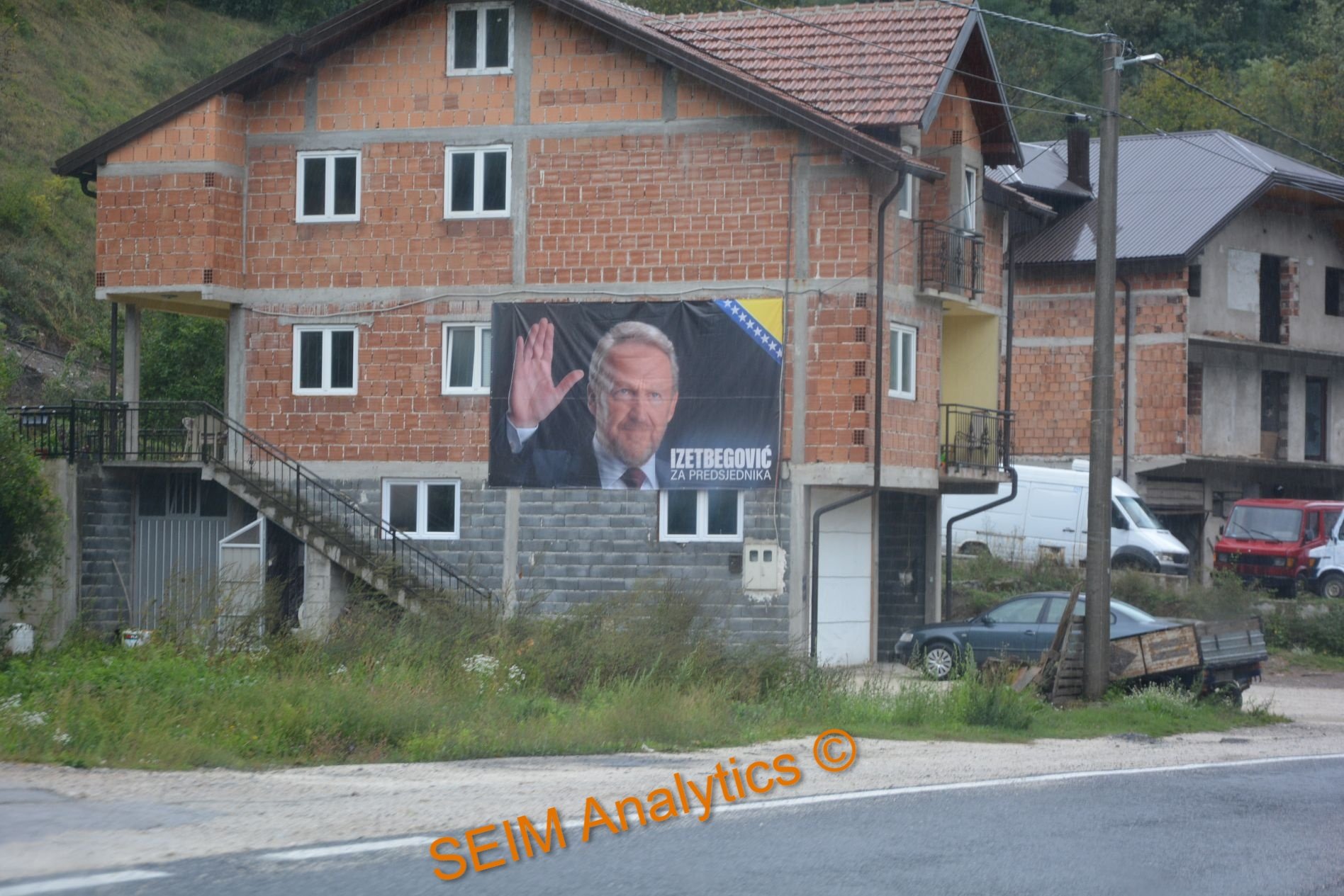 Election campaign poster in Konjic municipality showing Bakir Izetbegović, the son of Alija Izetbegović, the state leader that dragged Bosnia to war in 1992 when declining the Cutileiro Plan. Text saying, 'Izetbegović for President'.
