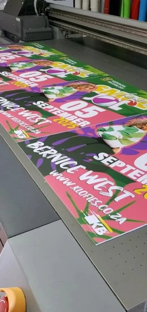 Large colorful posters for a September 2023 event, laying on a printing press, promoting a workplace event with the website www.101ret.co.za.