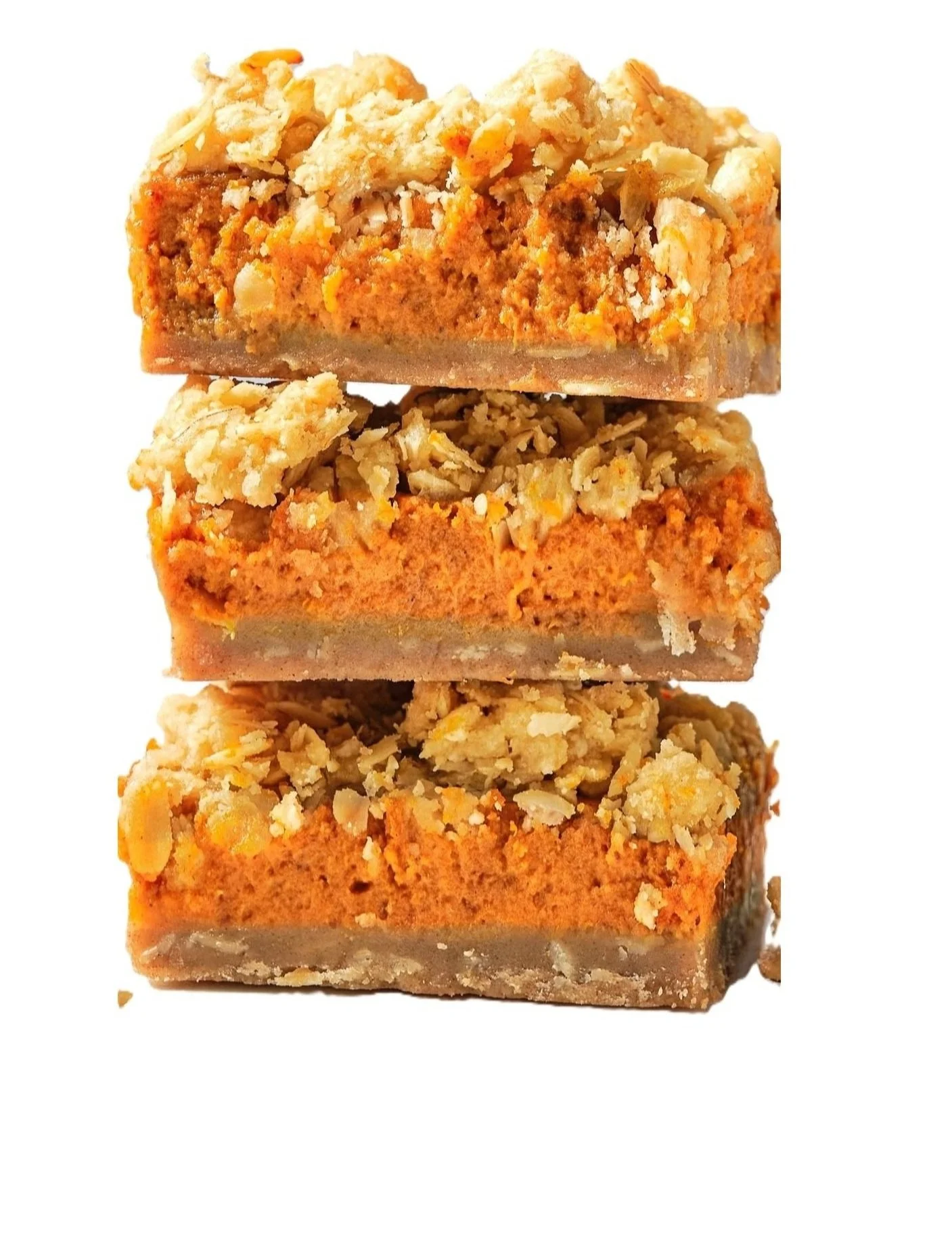 Pumpkin oat cookie bars stacked on a plate with golden crumble topping and warm fall lighting
