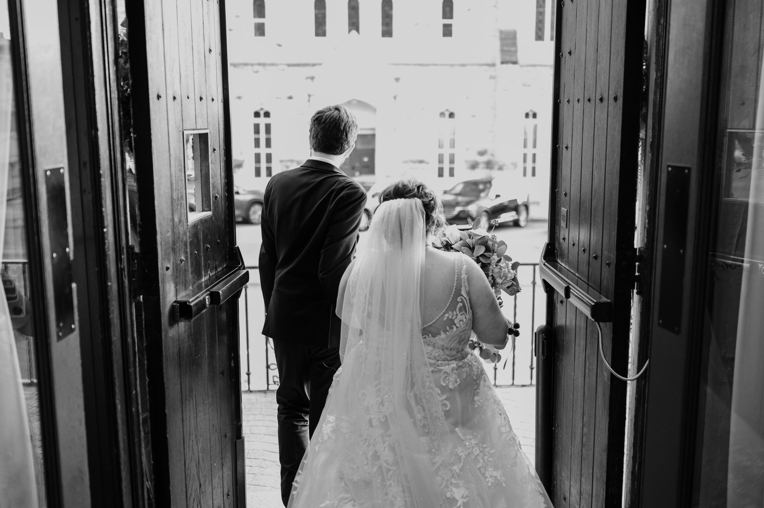 bride and groom exiting doors at the barnett event venue in st. louis.