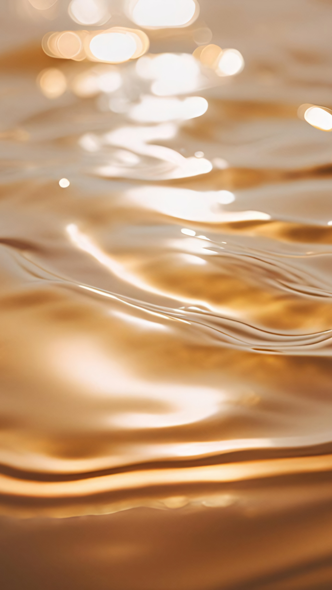 Close-up of golden reflections on water surface with soft blurred light in background.