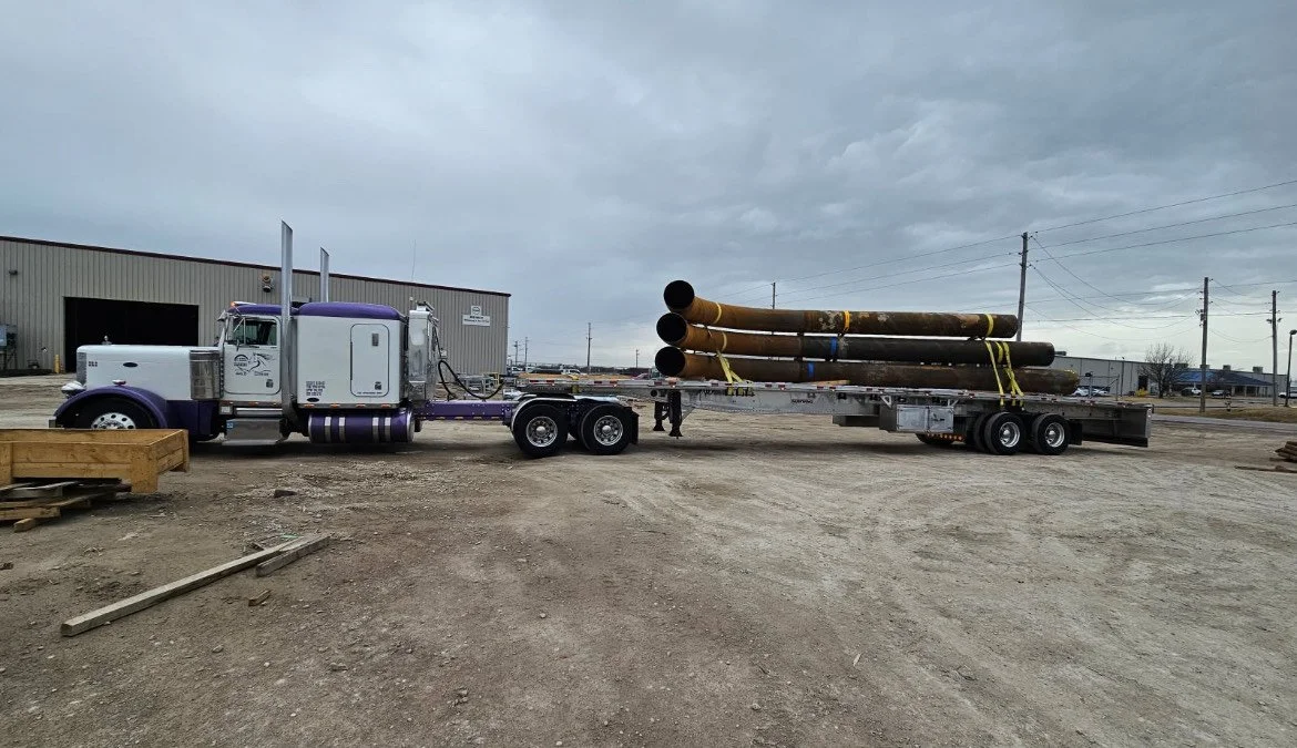 ICT flatbed hauling large steel pipe