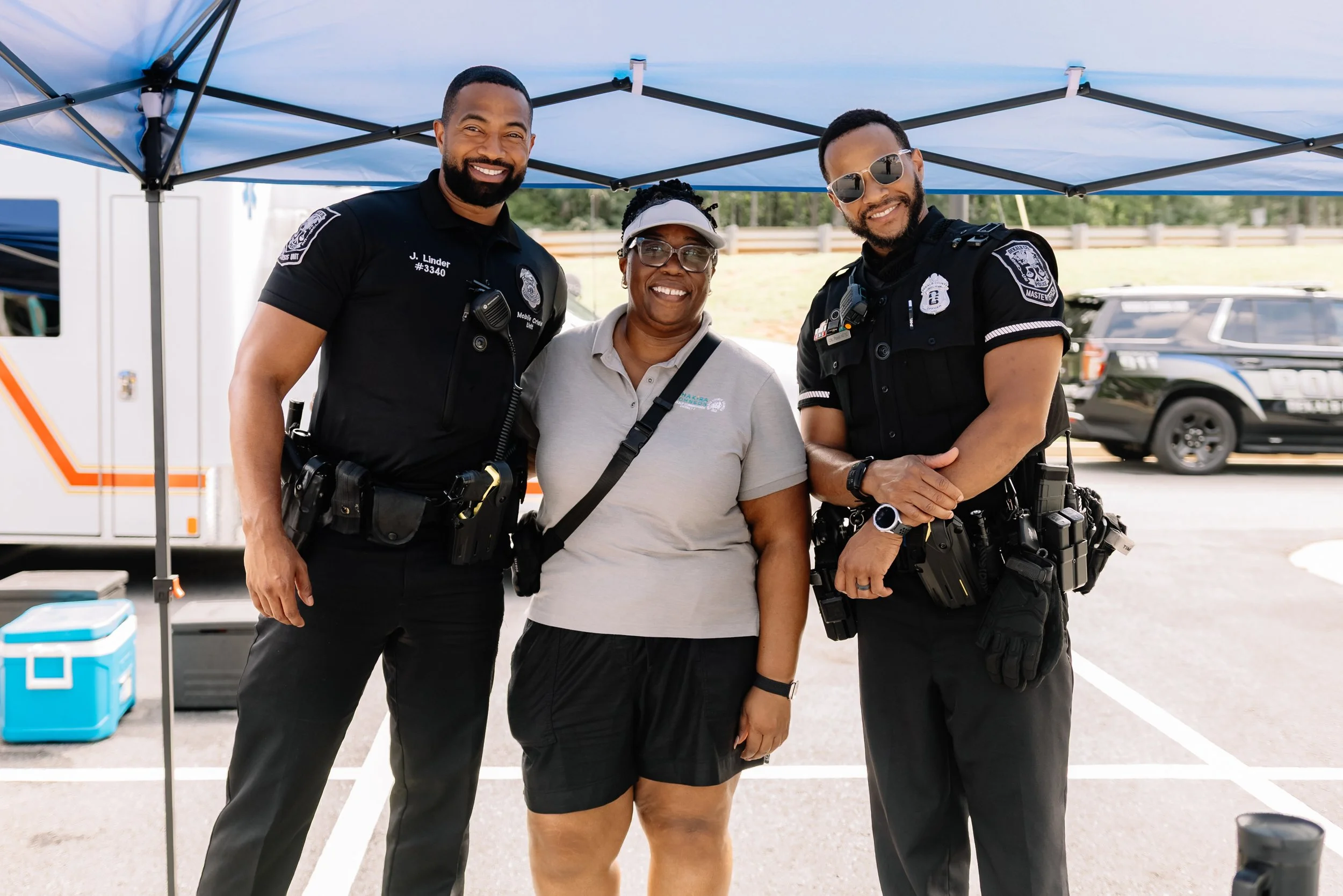 Commissioner Chakira Johnson poses with two DeKalb County Police officers at Chakira’s Cookout.